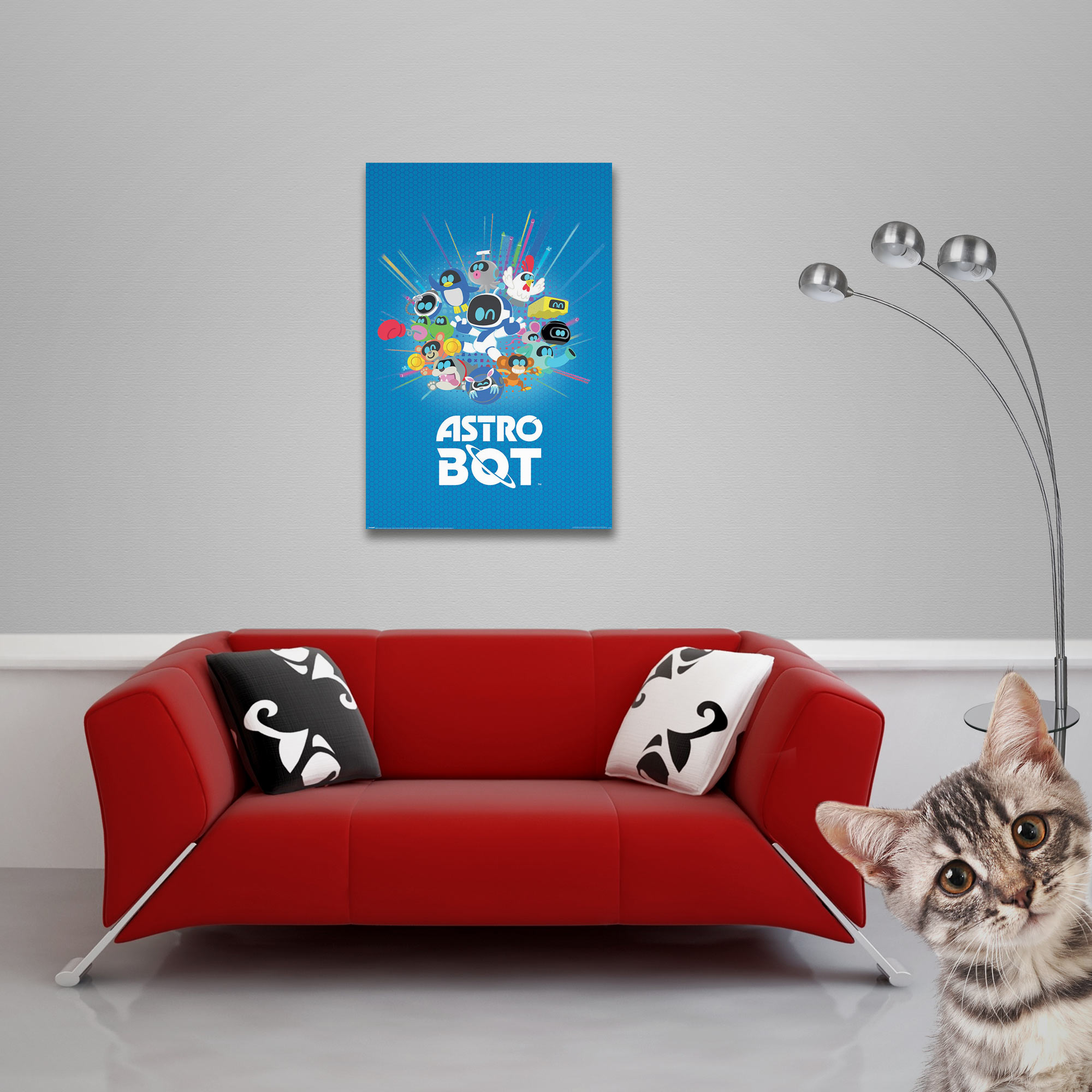 Ein rotes Sofa mit Kissen, ein Poster und eine Katze, die in die Kamera schaut.