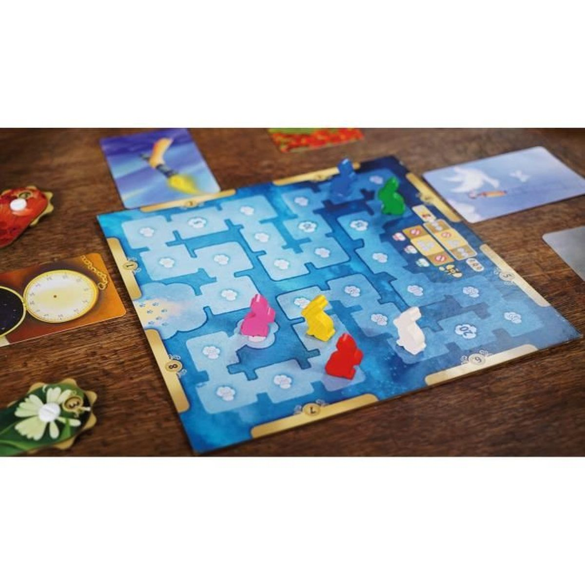 Brettspiel mit blauem Wassermabyrinth, bunten Kaninchenfiguren und Karten auf einem Holztisch.