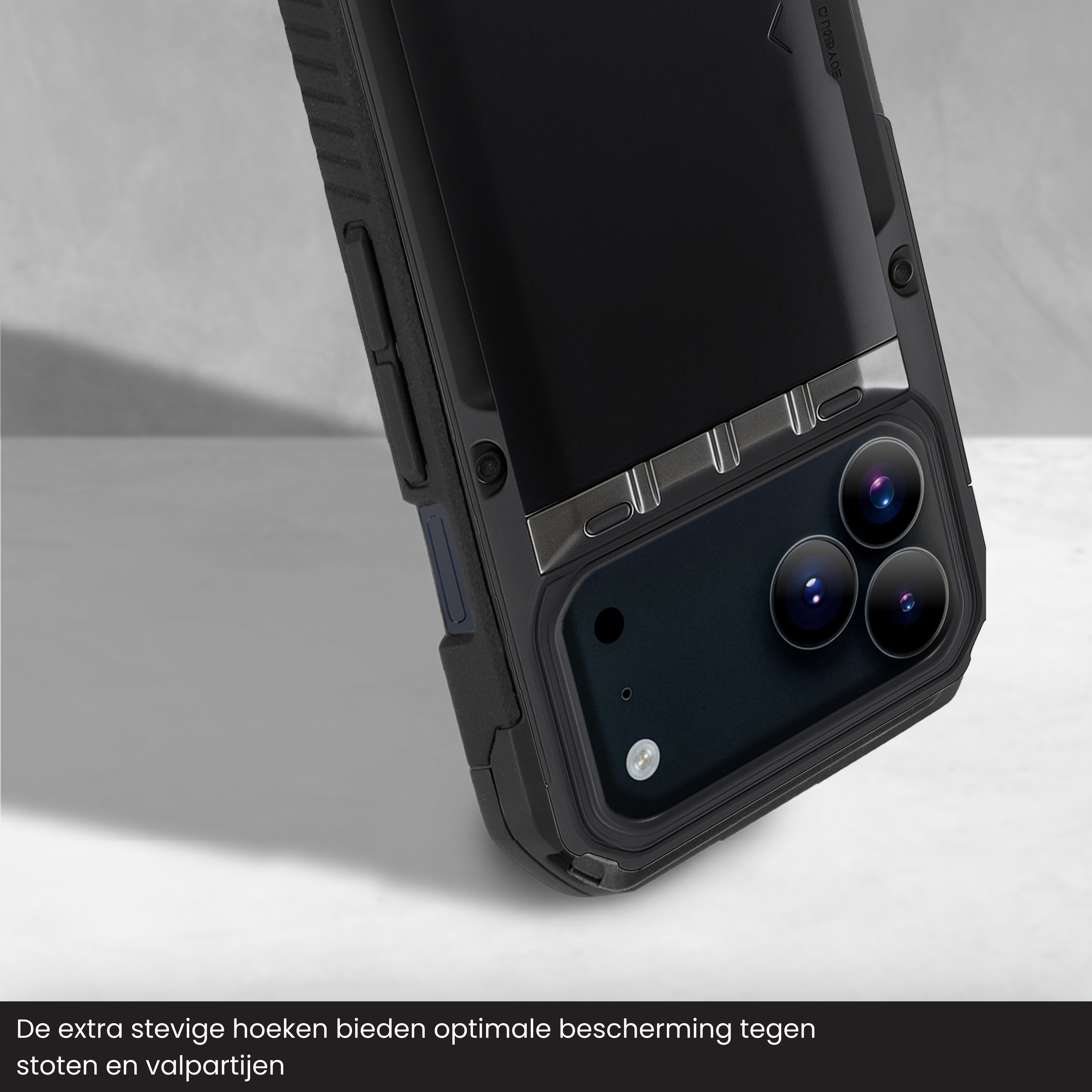 Close-up van een zwarte telefoonhoes. De hoes heeft een beschermend ontwerp met zichtbare cameralenzen. De achtergrond is lichtgrijs.