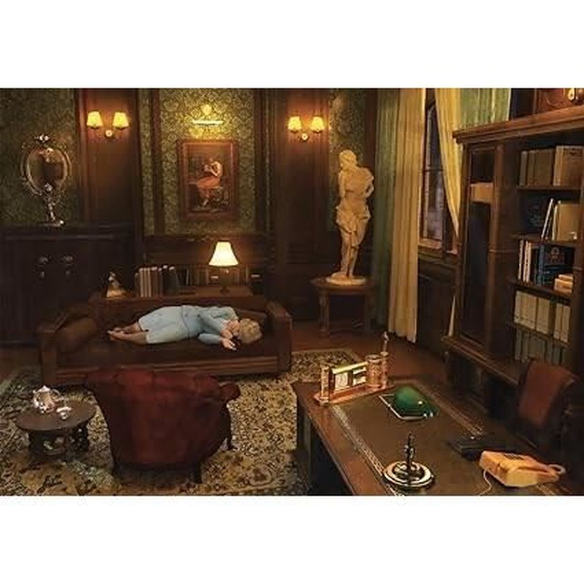 Eine Person liegt auf einem braunen Sofa in einem Raum mit Schreibtisch, Bücherregalen und einer Statue. Der Raum hat eine gemusterte Tapete und einen Vintage-Look.