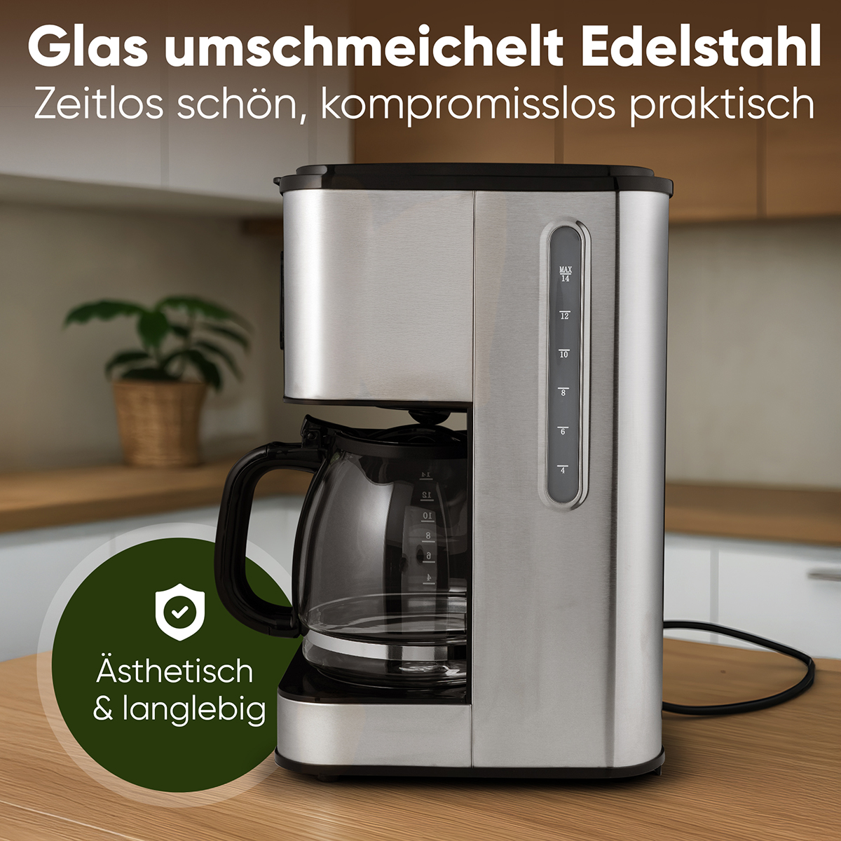 Eine Kaffeemaschine aus Edelstahl mit Glaskaraffe. Ein grüner Kreis mit Text und eine Pflanze im Hintergrund.