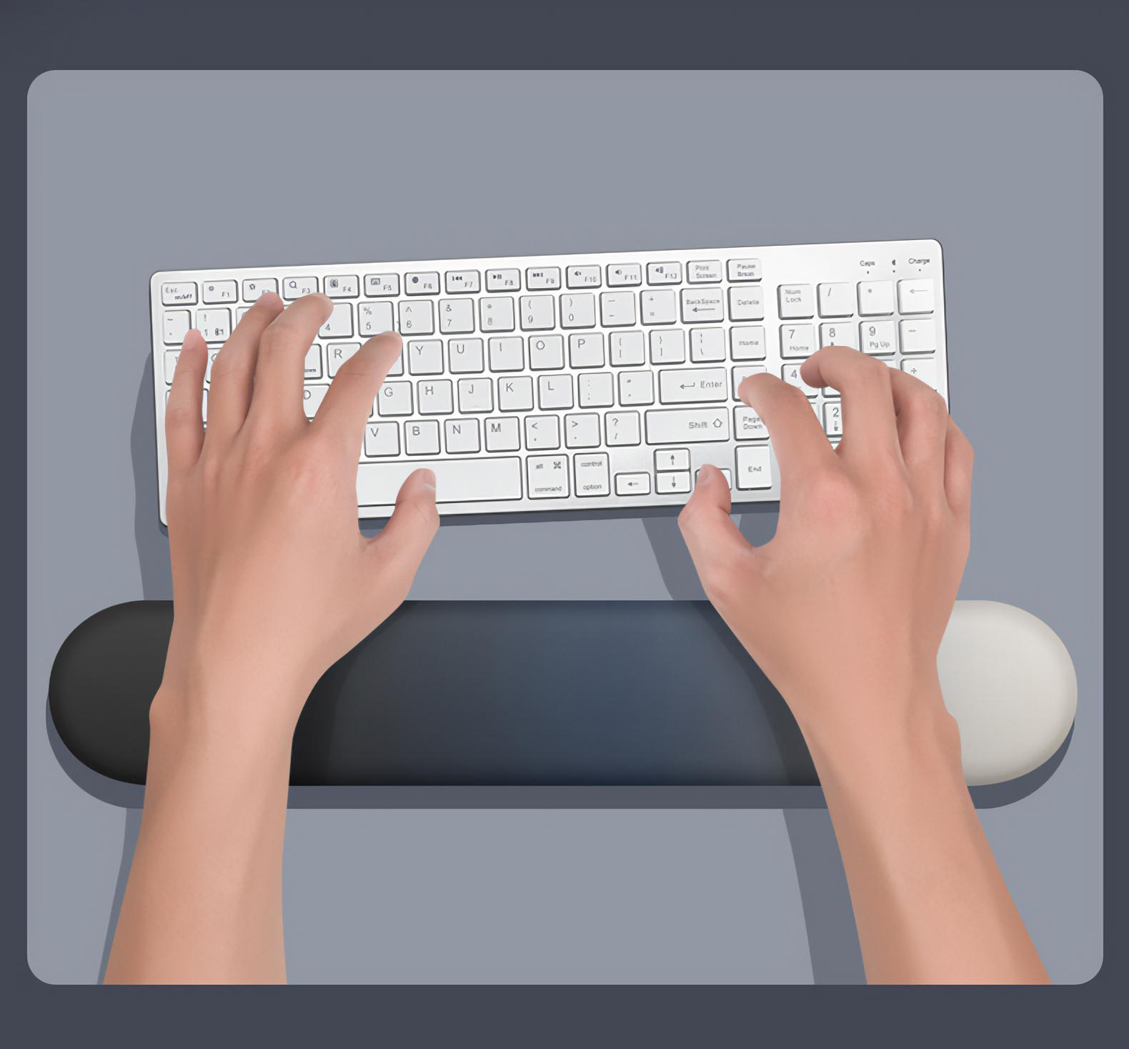 Hände tippen auf einer weißen Tastatur mit schwarzer Handgelenkauflage. Grauer Hintergrund.
