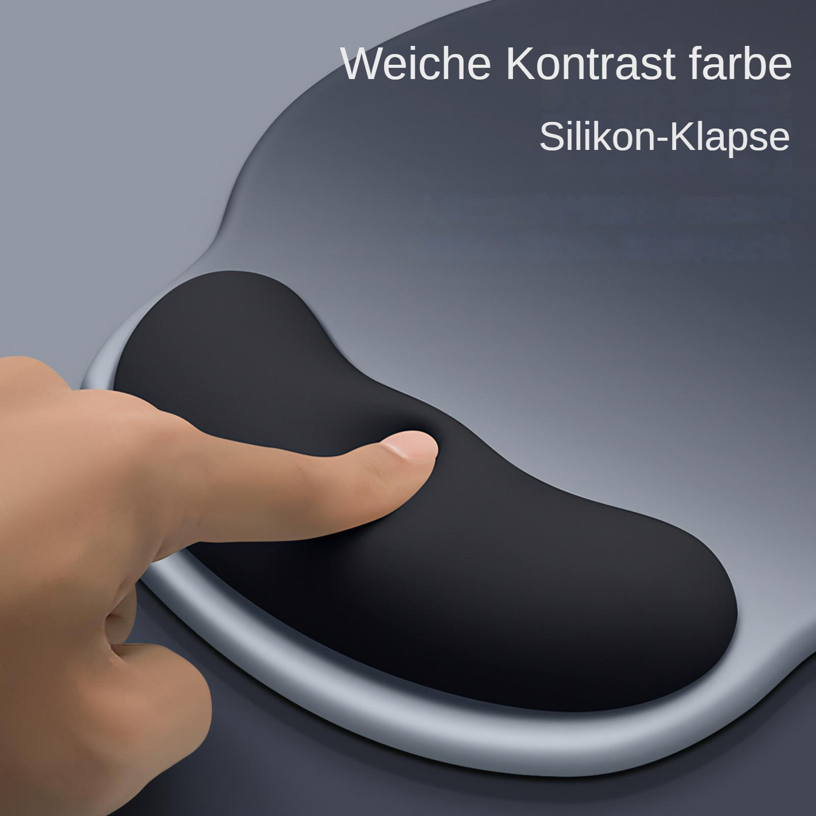 Eine Hand drückt einen Finger in eine schwarze Handgelenkauflage. Die Auflage befindet sich auf einer grauen Oberfläche. Text auf Deutsch im Hintergrund.