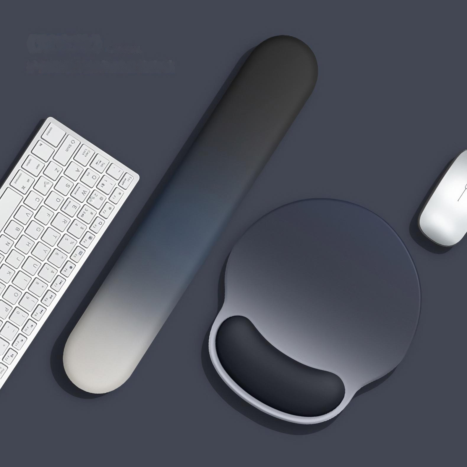 Eine Tastatur, eine Handgelenkauflage, ein Mauspadd mit Handgelenkstütze und eine Maus liegen auf einer dunklen Oberfläche.