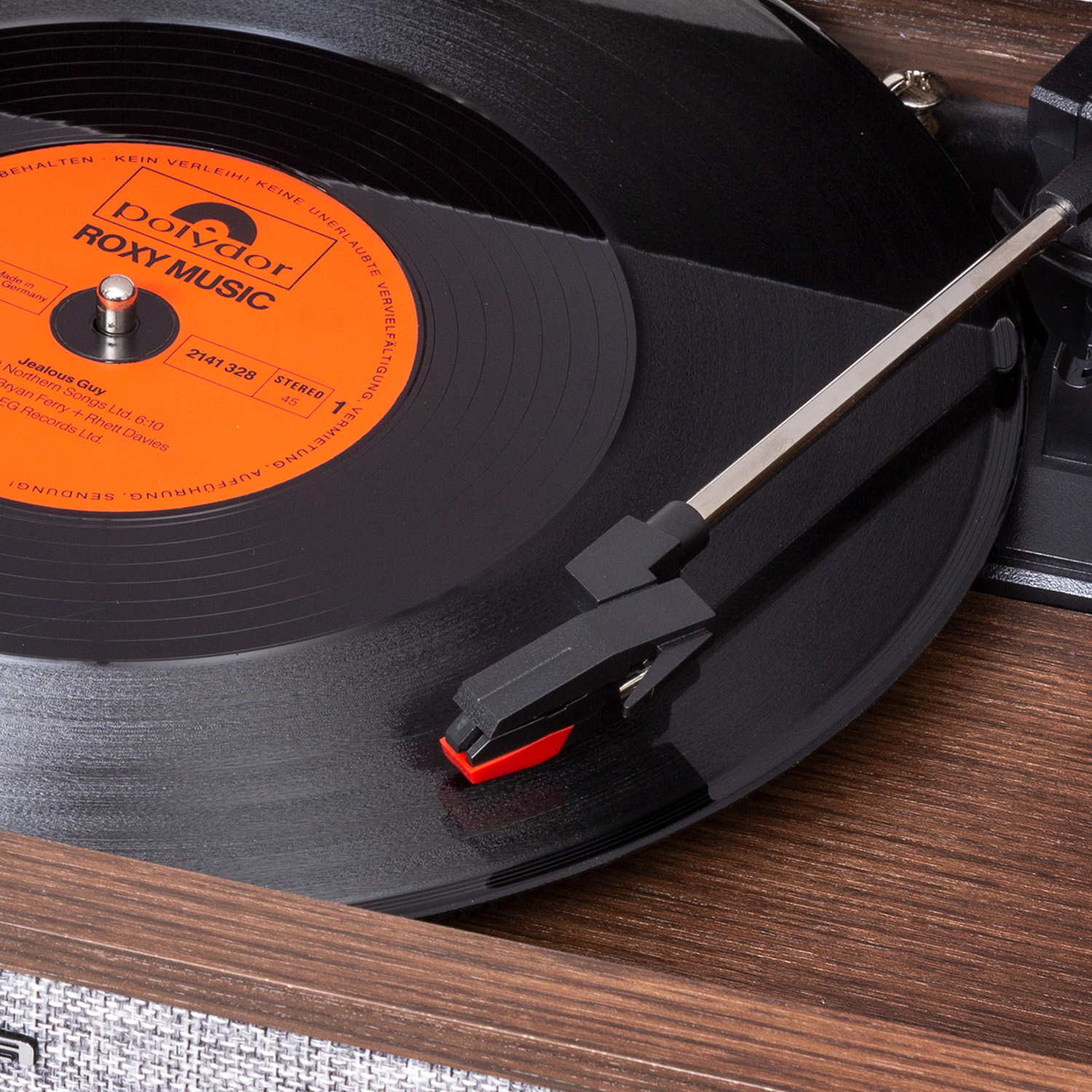 Ein Plattenspieler spielt eine schwarze Schallplatte ab. Das Etikett der Schallplatte ist orange mit dem Text 'Roxy Music'. Die Nadel liegt auf der Platte.