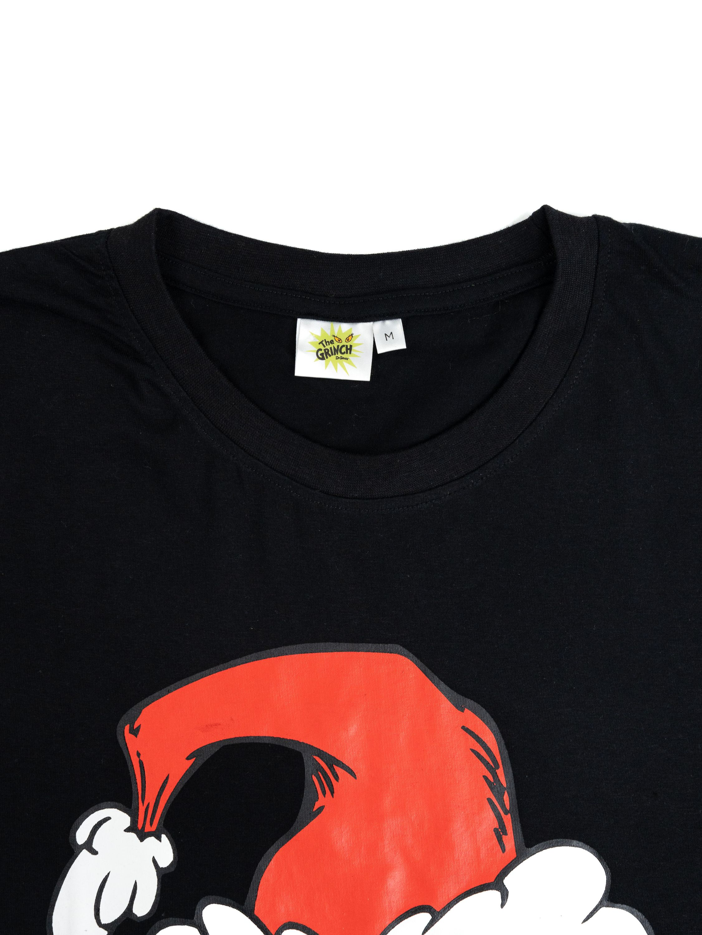 Schwarzes T-Shirt mit Grinch-Design. Roter Hut und weißes Fell. Das Grinch-Logo und das Größenetikett sind am Kragen sichtbar.
