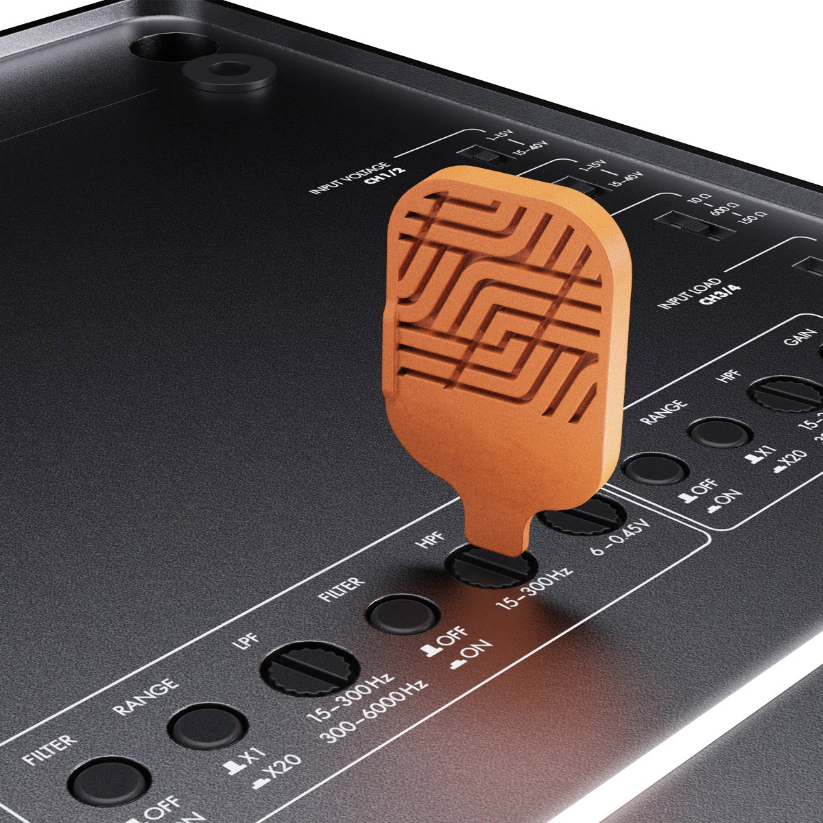 Ein orangefarbener Hebel wird in eine schwarze Tafel mit Beschriftungen, Knöpfen und Text eingefügt. Die Tafel ist Teil elektronischer Geräte.