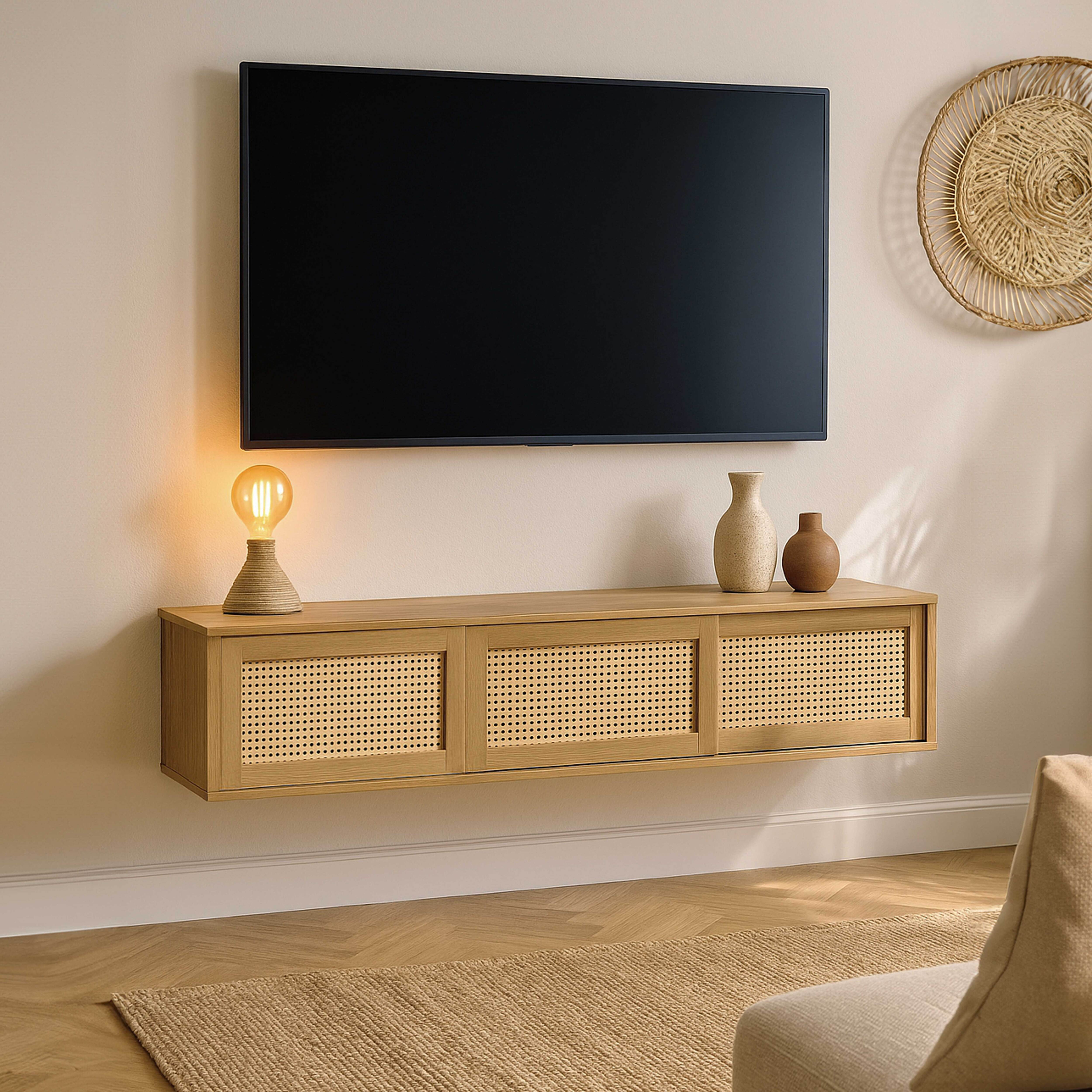 Ein Fernseher über einem Holzschrank mit Korbtüren. Eine Lampe und Vasen stehen auf dem Schrank. Es gibt einen Teppich.