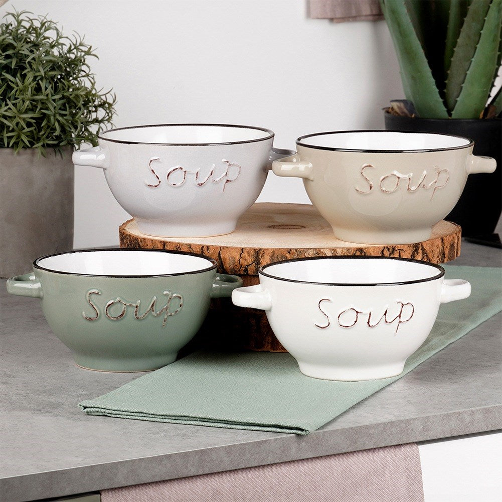 Cuatro cuencos de sopa de diferentes colores, sobre una mesa. Cada cuenco tiene escrito 'Sopa'. También se ve una servilleta verde.