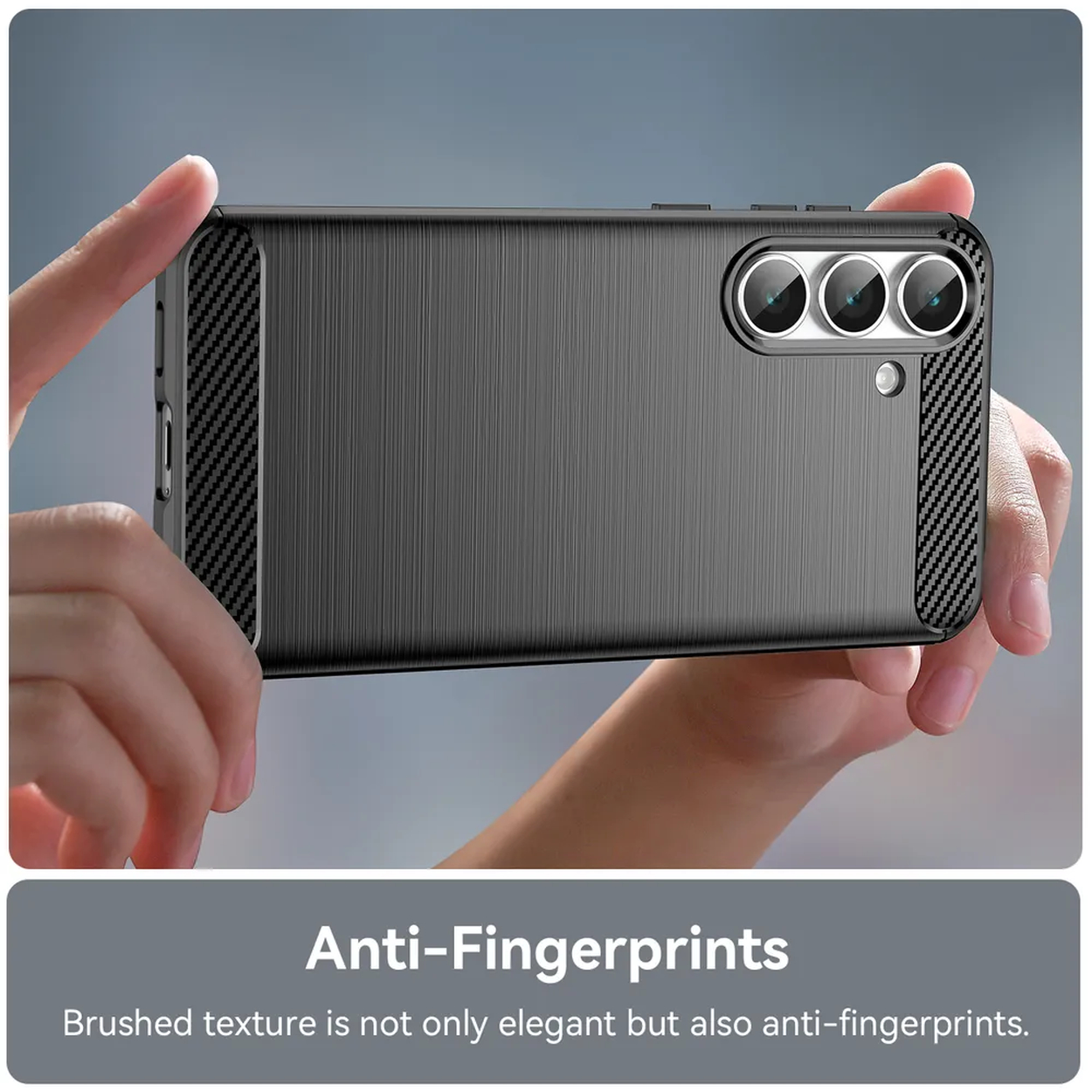 Een telefoonhoesje vastgehouden door handen. Het is donkergrijs met een geborstelde textuur en carbon fiber accenten. De hoes heeft drie lenzen.