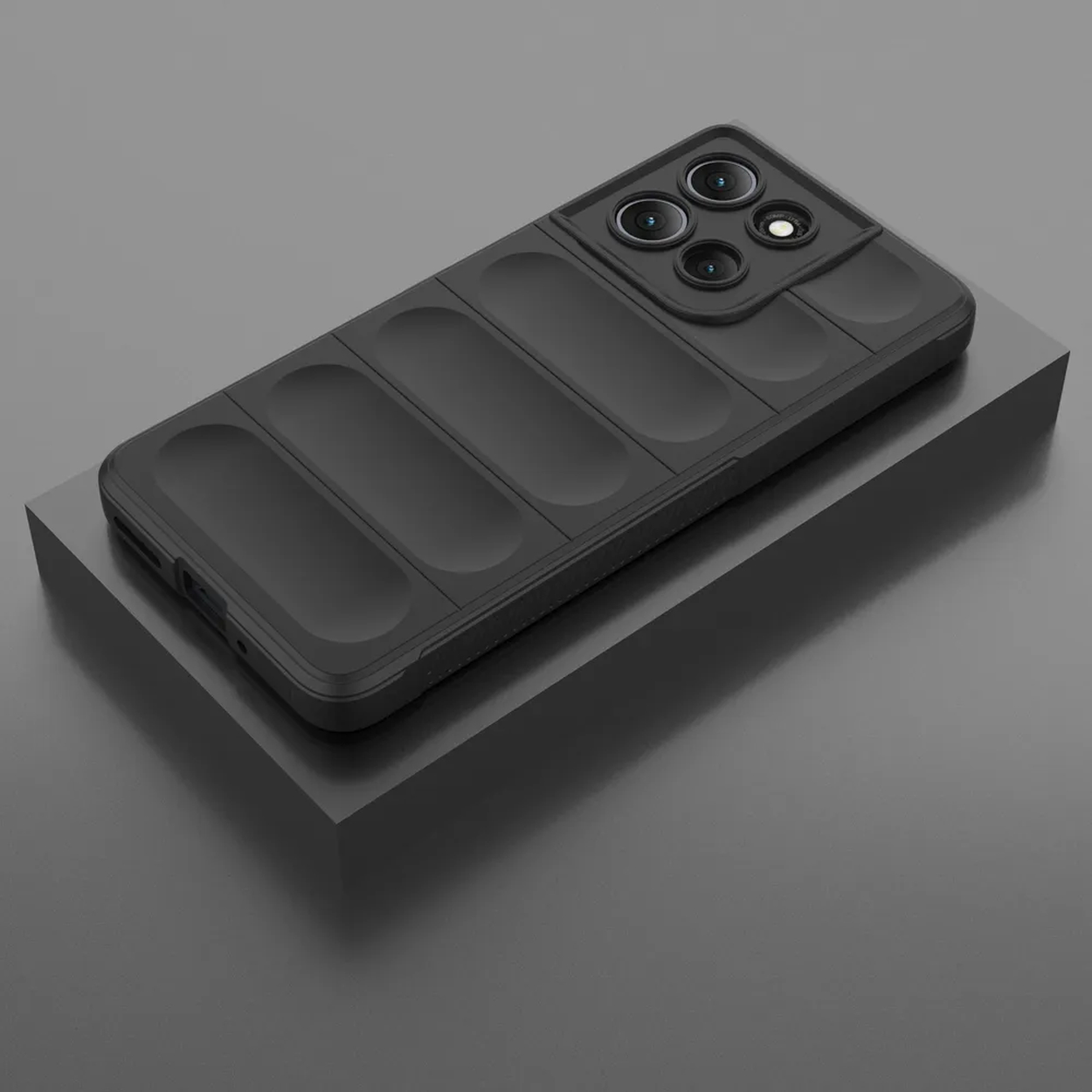 Een zwarte telefoonhoes met een cameramodule en een geribbeld ontwerp, geplaatst op een zwart platform tegen een grijze achtergrond.
