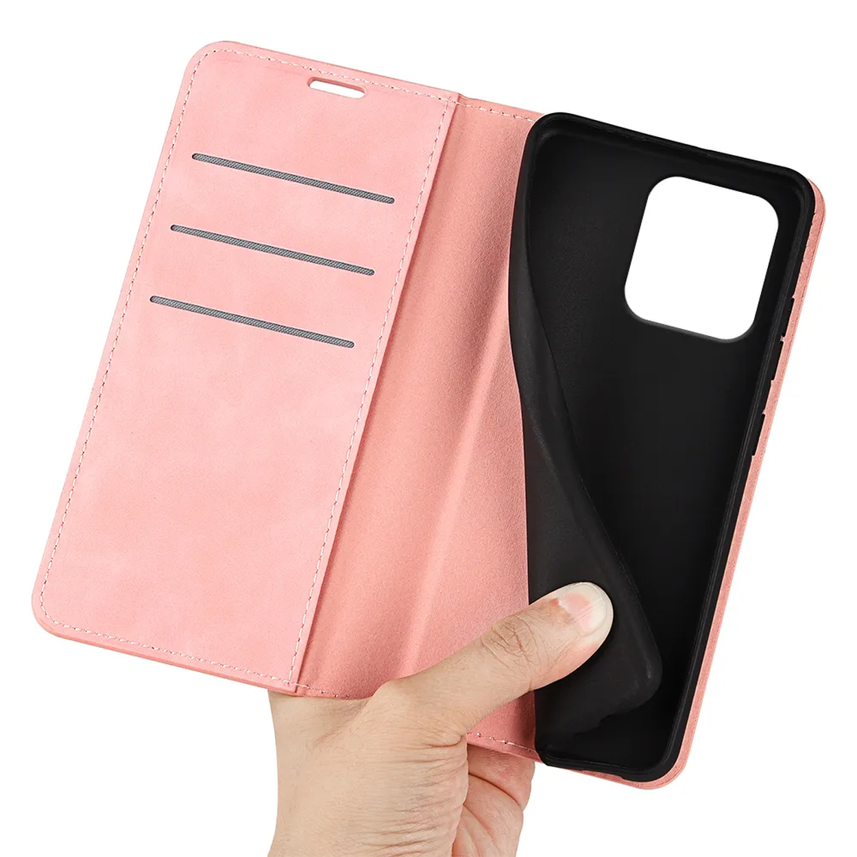 A hand holds a pink phone case, open to reveal a black interior. The case has card slots and a small hole at the top.