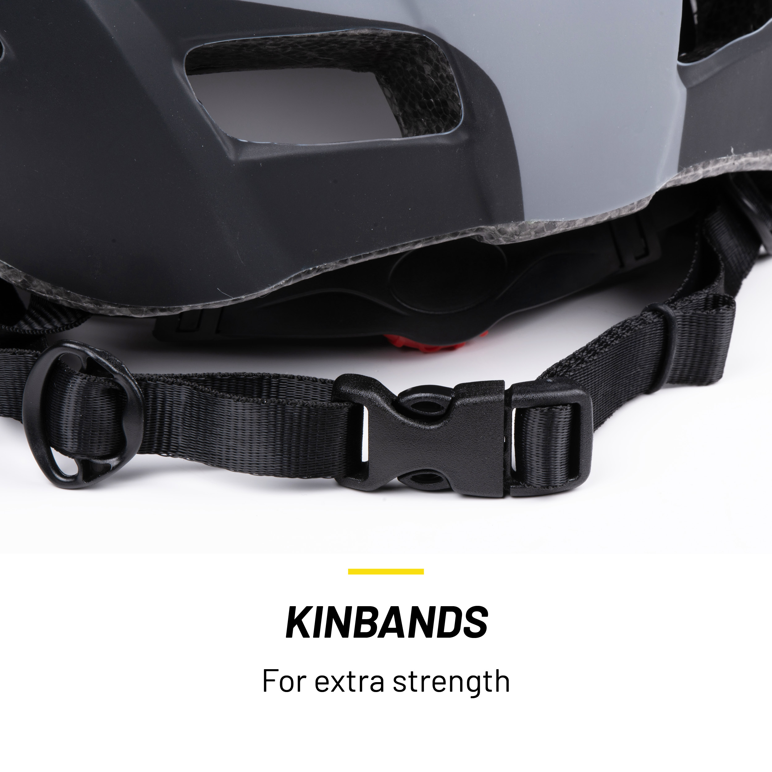 Close-up van een zwarte en grijze helm met een zwarte riem en gesp. De tekst 'KINBANDS' is zichtbaar.