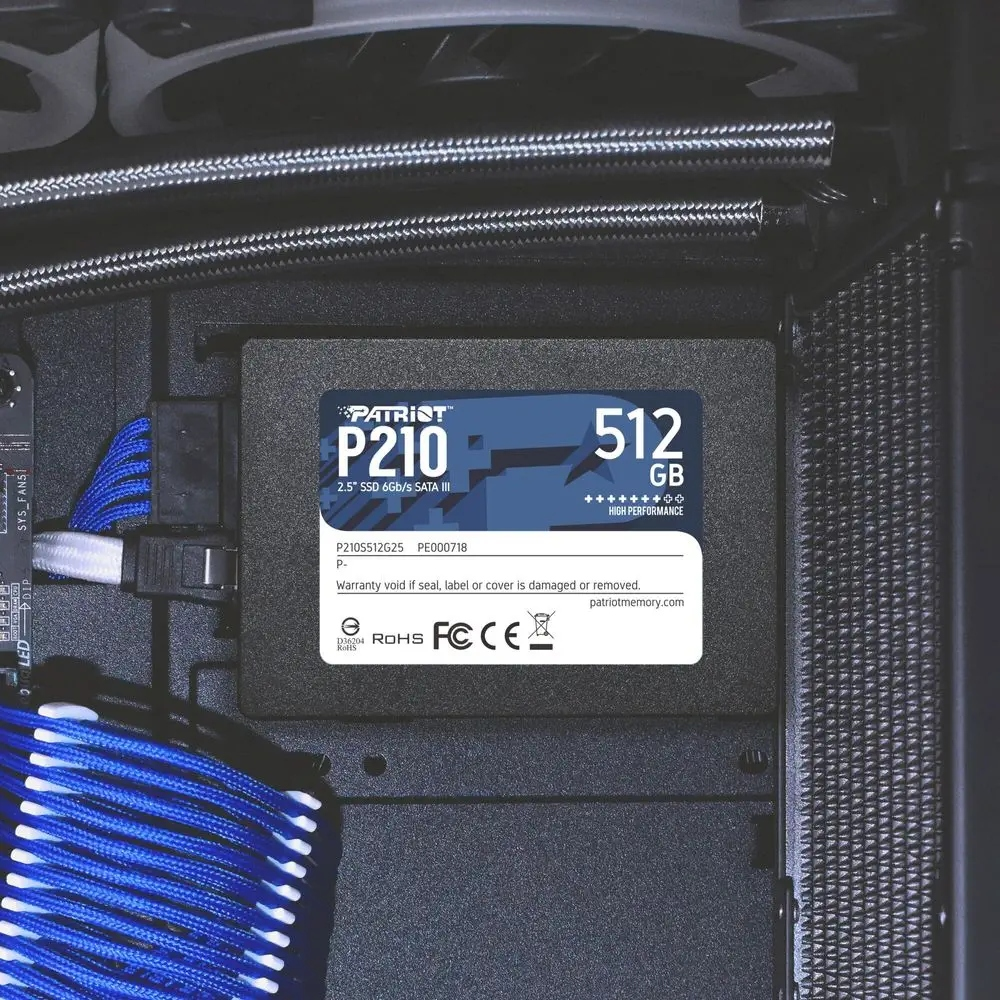 Dysk SSD Patriot P210 512GB zainstalowany w obudowie komputera. Widoczne niebieskie i białe kable oraz inne elementy.