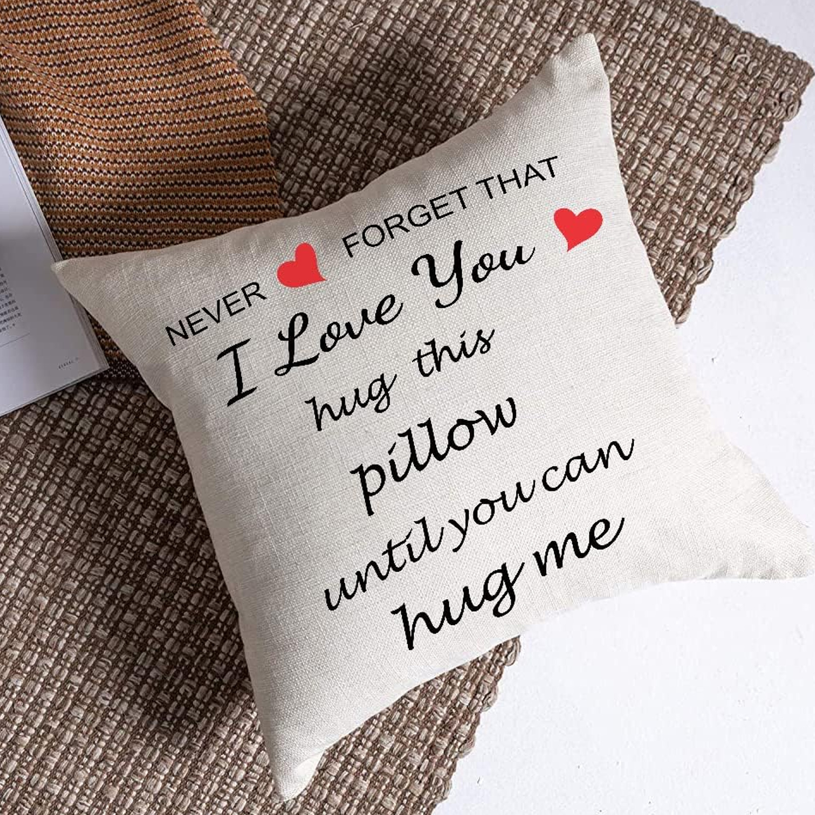 Weißes Kissen mit schwarzem Text: „Vergiss nie, dass ich dich liebe, umarme dieses Kissen, bis du mich umarmen kannst.“ Rote Herzen.