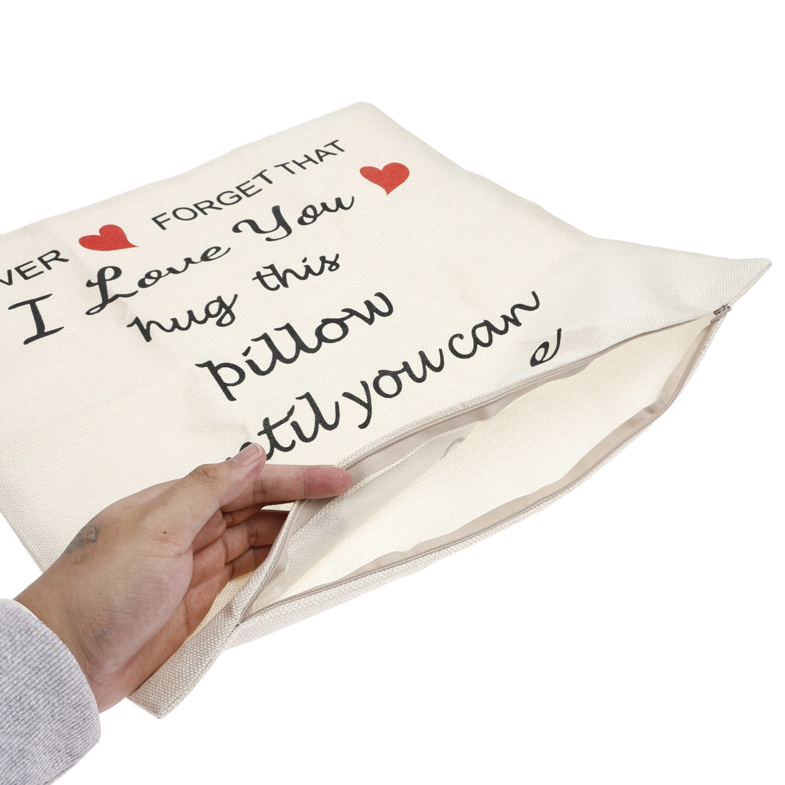 Ein Kissen mit Text: „Ich liebe dich“. Eine Hand hält das Kissen offen und zeigt die Innenseite.