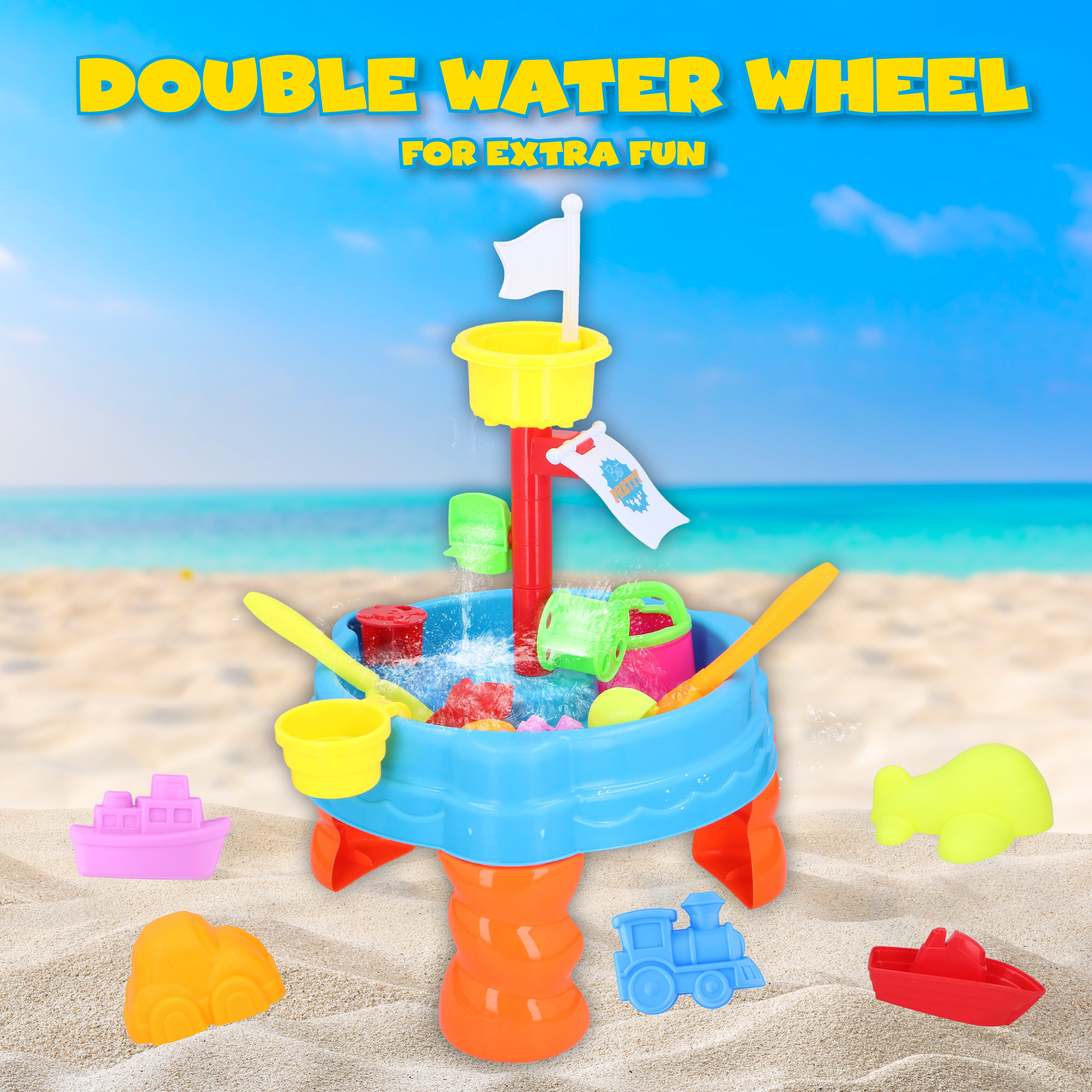 A beach-themed playset with a water wheel, flags, and colorful sand molds on a sandy beach with a blue sky.