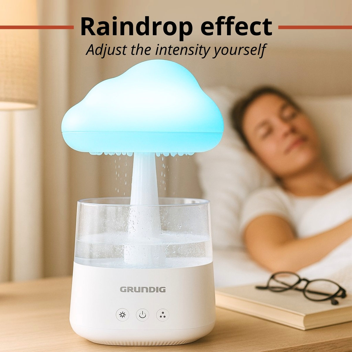A white humidifier with a cloud-shaped top emits water. A woman sleeps in the background. Glasses and a book are on the nightstand.