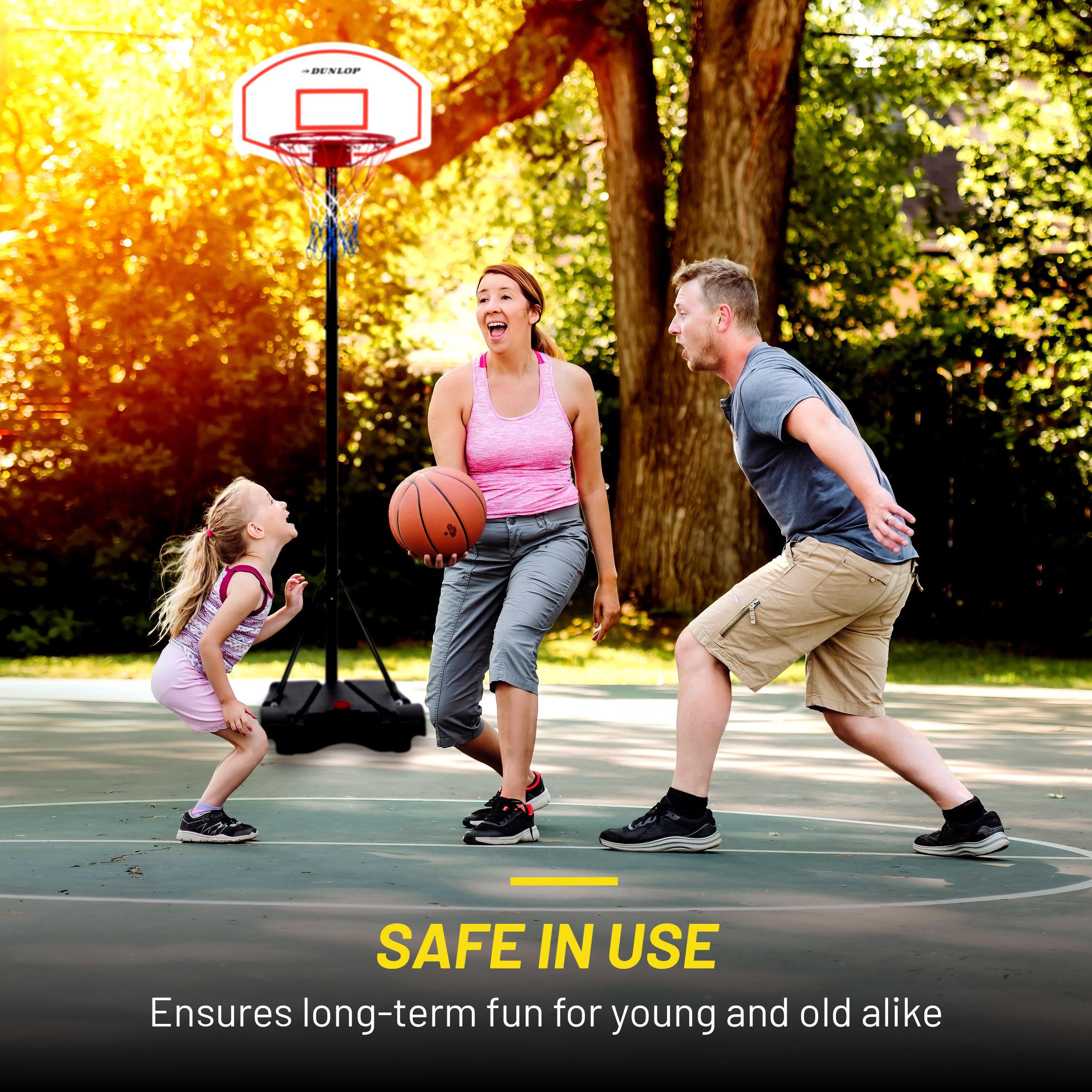 A family plays basketball. A woman holds the ball, a girl looks up, and a man runs.