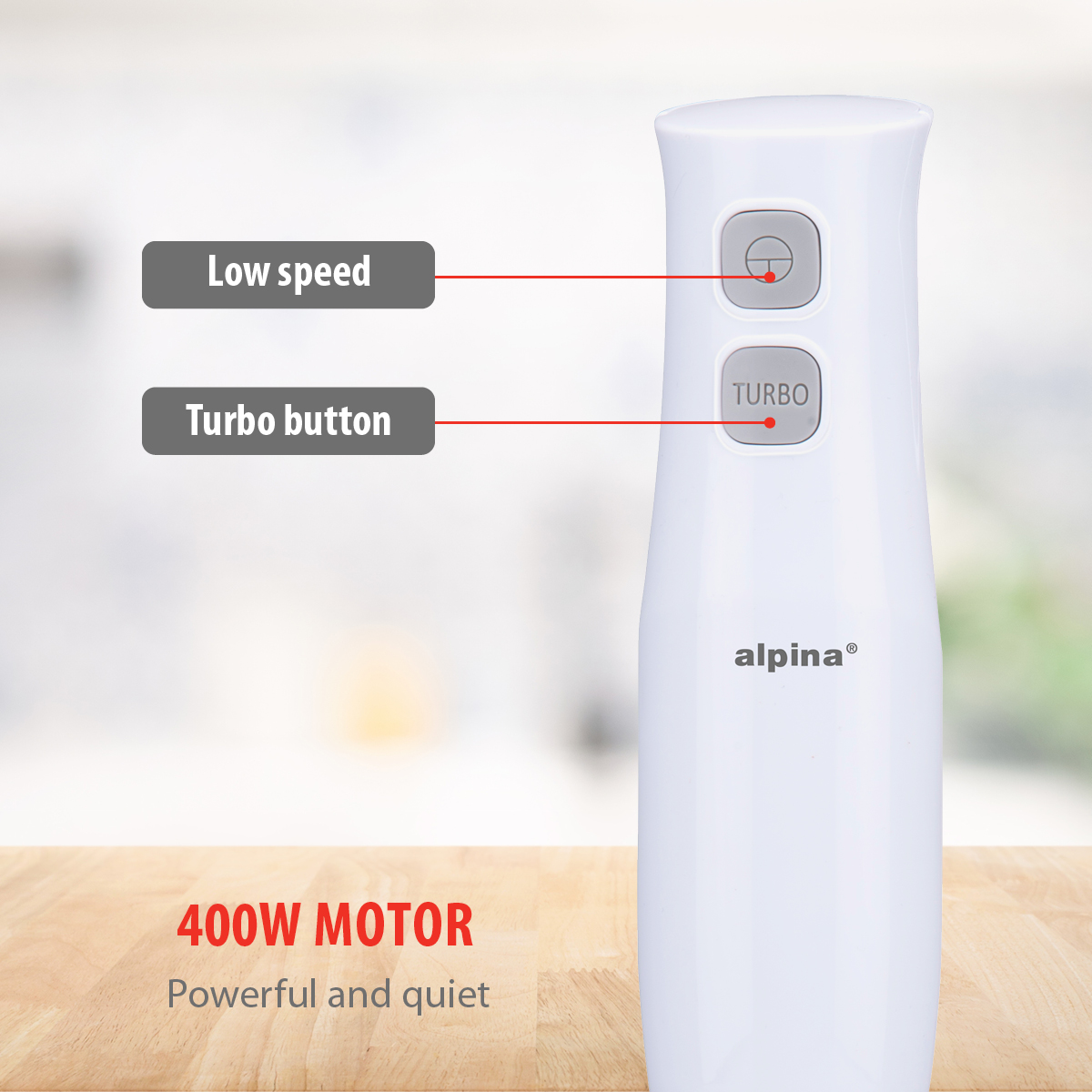 Een witte staafmixer met turboknop en lage snelheidsknop wordt getoond op een houten oppervlak. De achtergrond is wazig.