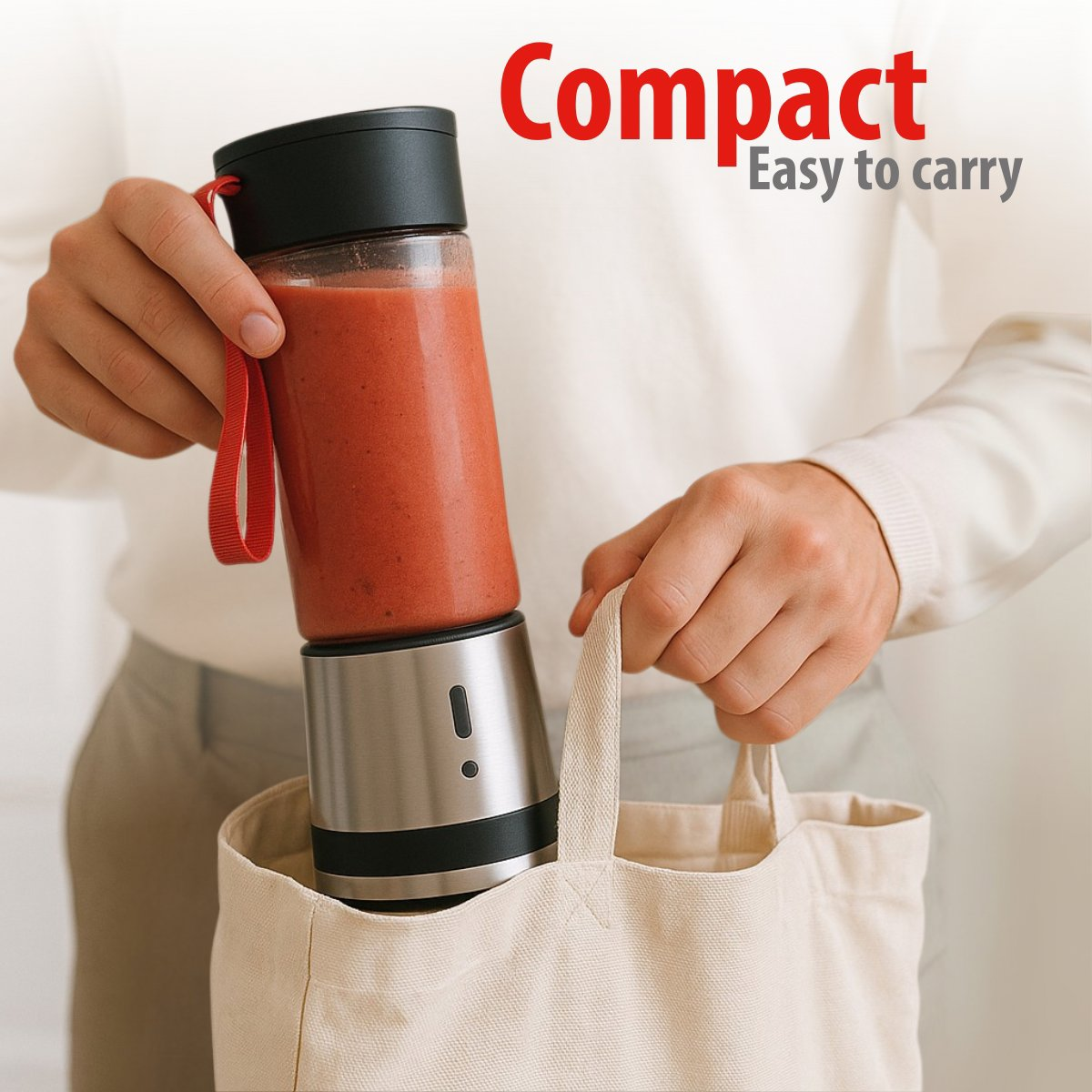 Een persoon houdt een smoothie maker vast en stopt hem in een beige draagtas. De smoothie maker is gevuld met rode vloeistof.