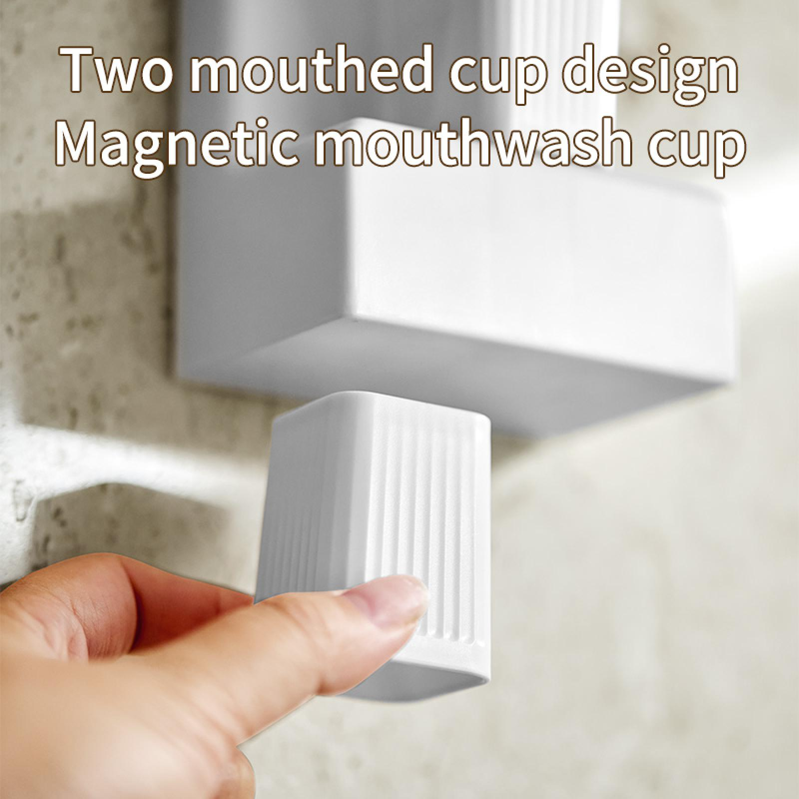 Eine Hand, die einen weißen, geriffelten Becher hält. Oben befindet sich ein größerer weißer Behälter. Text: 'Zwei Mundbecher-Design Magnetischer Mundspülbecher'.