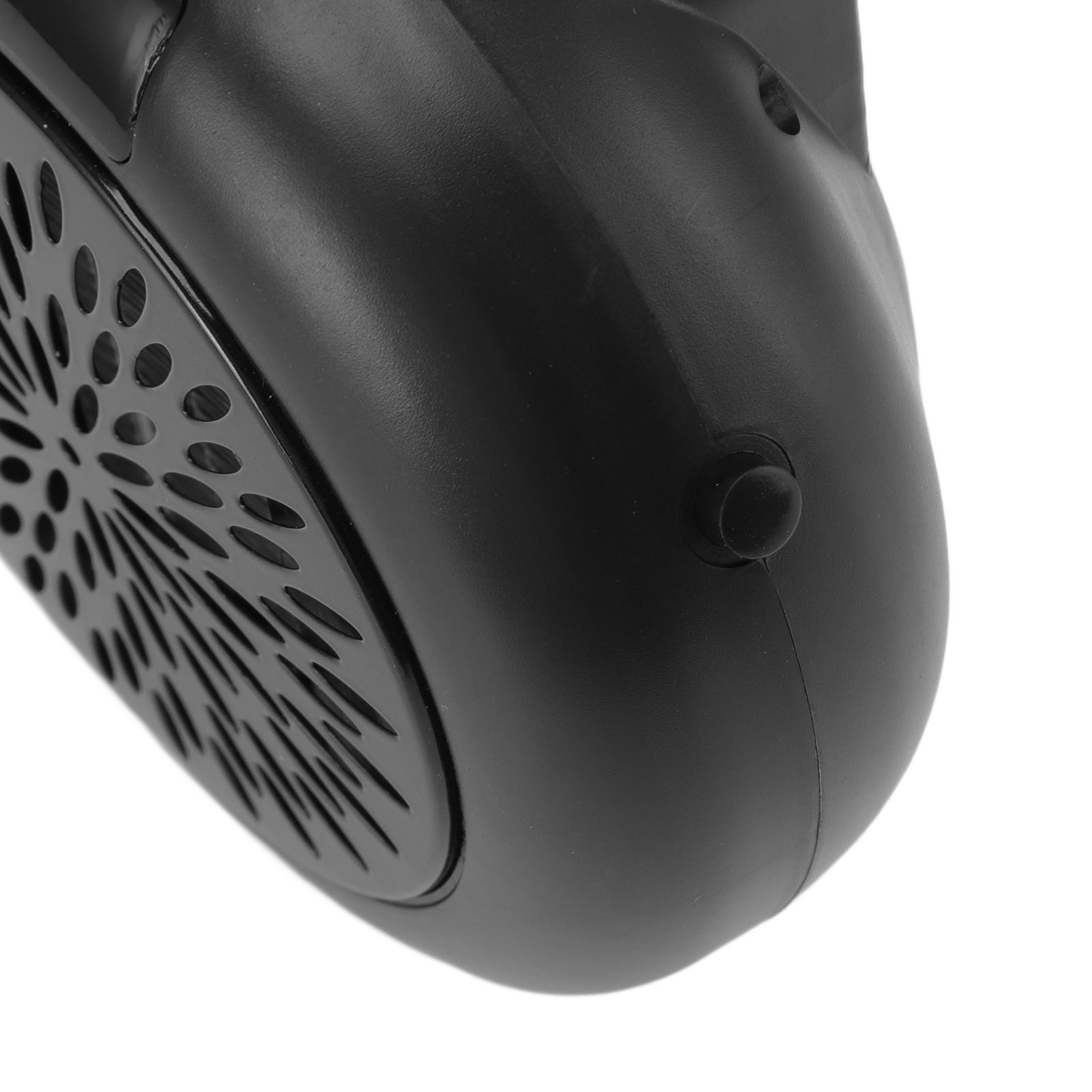 Nahaufnahme eines schwarzen Plastikgeräts mit perforiertem Grill und abgerundeter Oberfläche mit Knopf. Weißer Hintergrund.