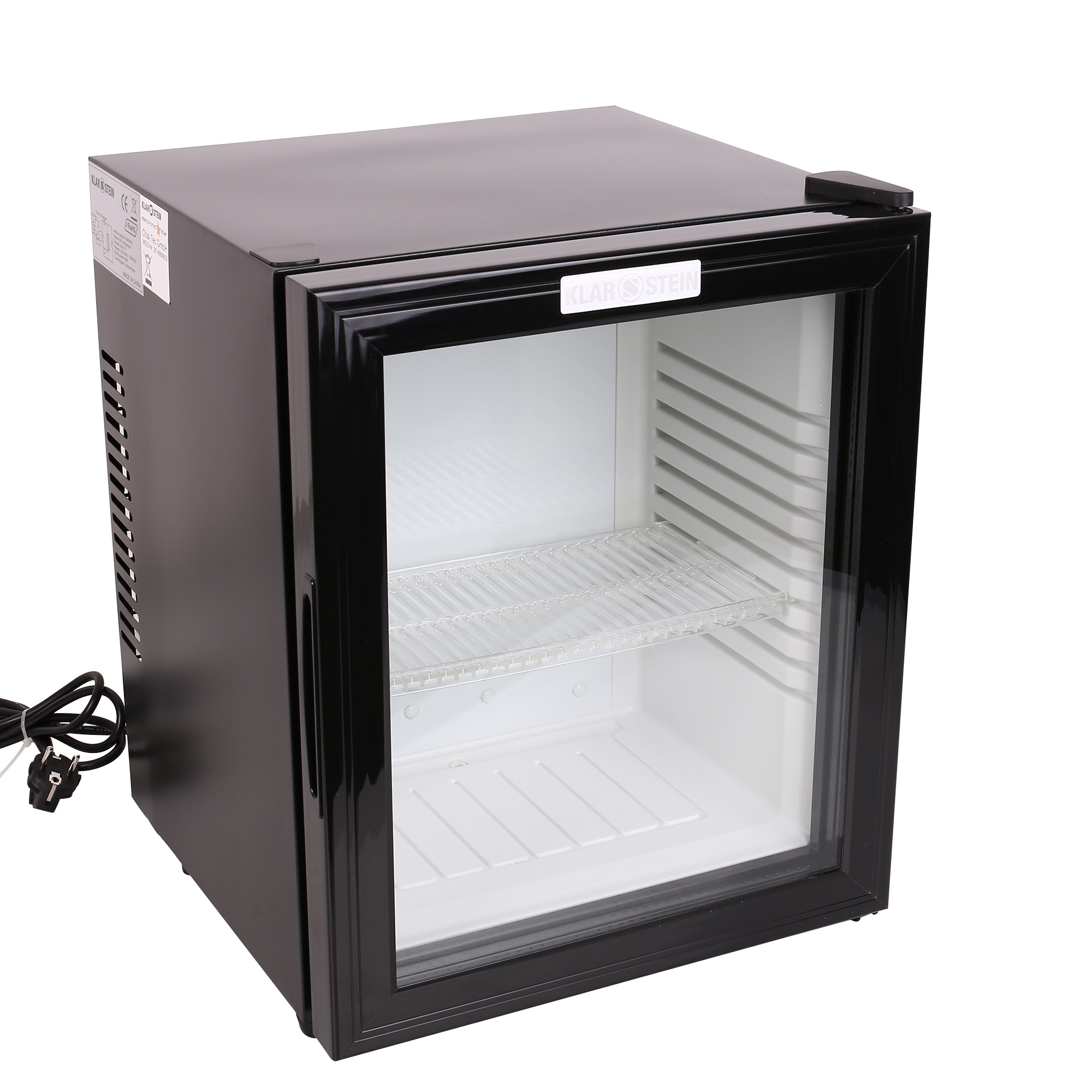 Un pequeño mini refrigerador negro con puerta de vidrio. Tiene un estante de metal en el interior. Se ve un cable de alimentación con enchufe.