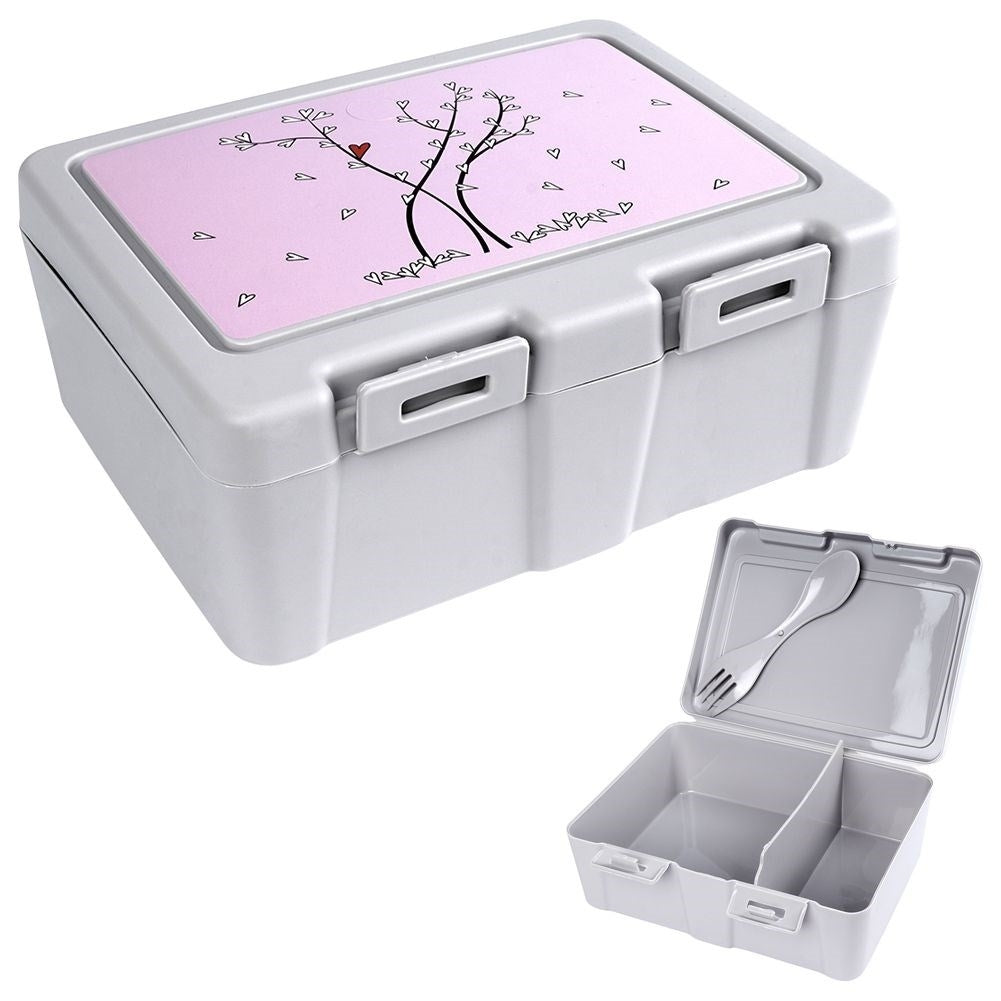 Una fiambrera gris con tapa rosa decorada con un árbol y corazones. Una caja más pequeña y abierta con tenedor y cuchara.