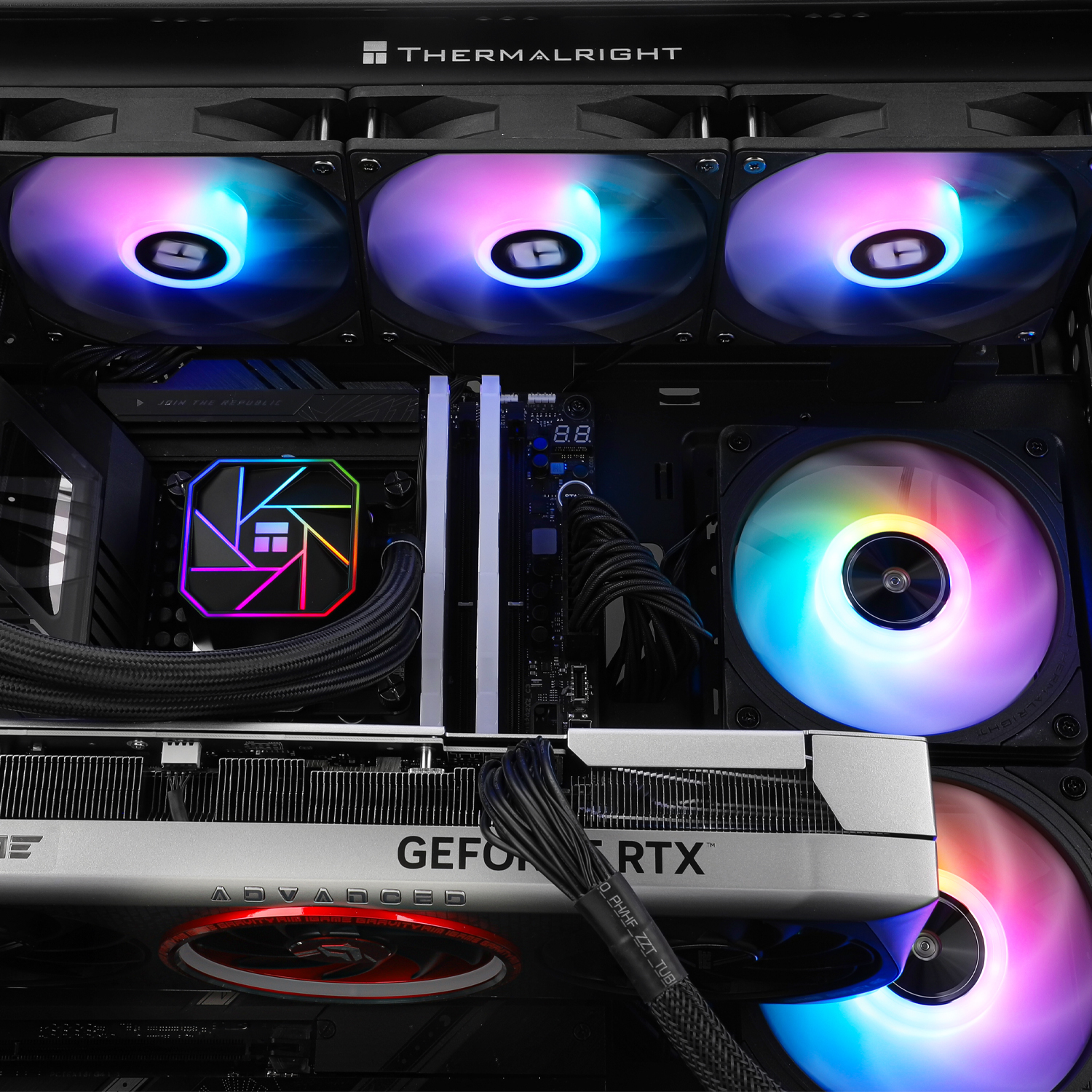 Sono visualizzati i componenti interni di un computer, tra cui ventole con luci colorate, una scheda grafica e un dissipatore CPU.