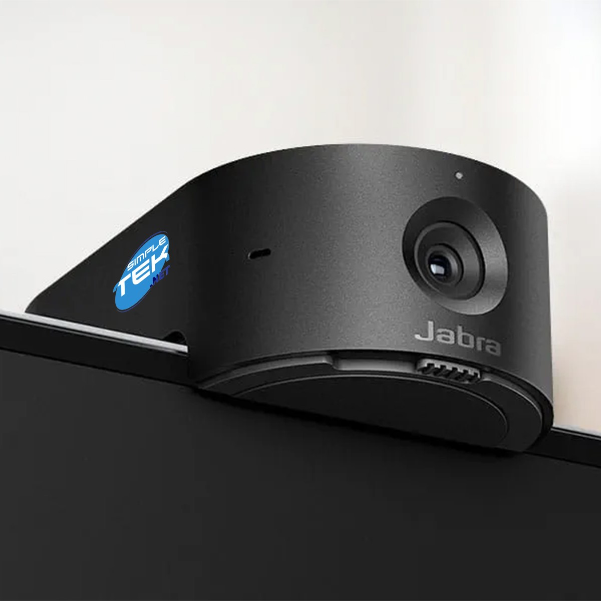 Una webcam Jabra nera è montata su un monitor. Ha il logo Jabra e un adesivo con il logo Simple Tek .net.