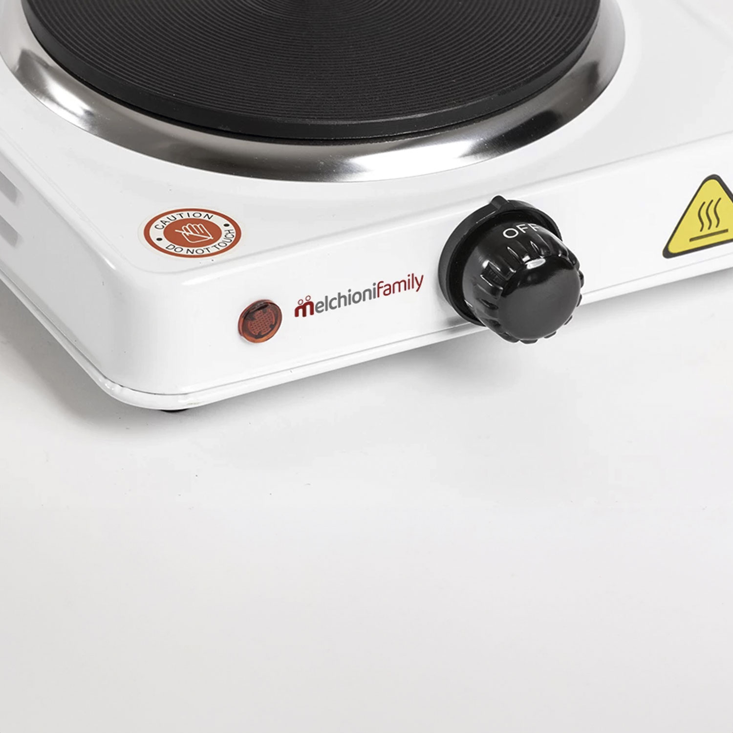 Zbliżenie białej kuchenki elektrycznej z czarnym palnikiem. Czarny przycisk z napisem 'OFF'. Widoczna naklejka ostrzegawcza.