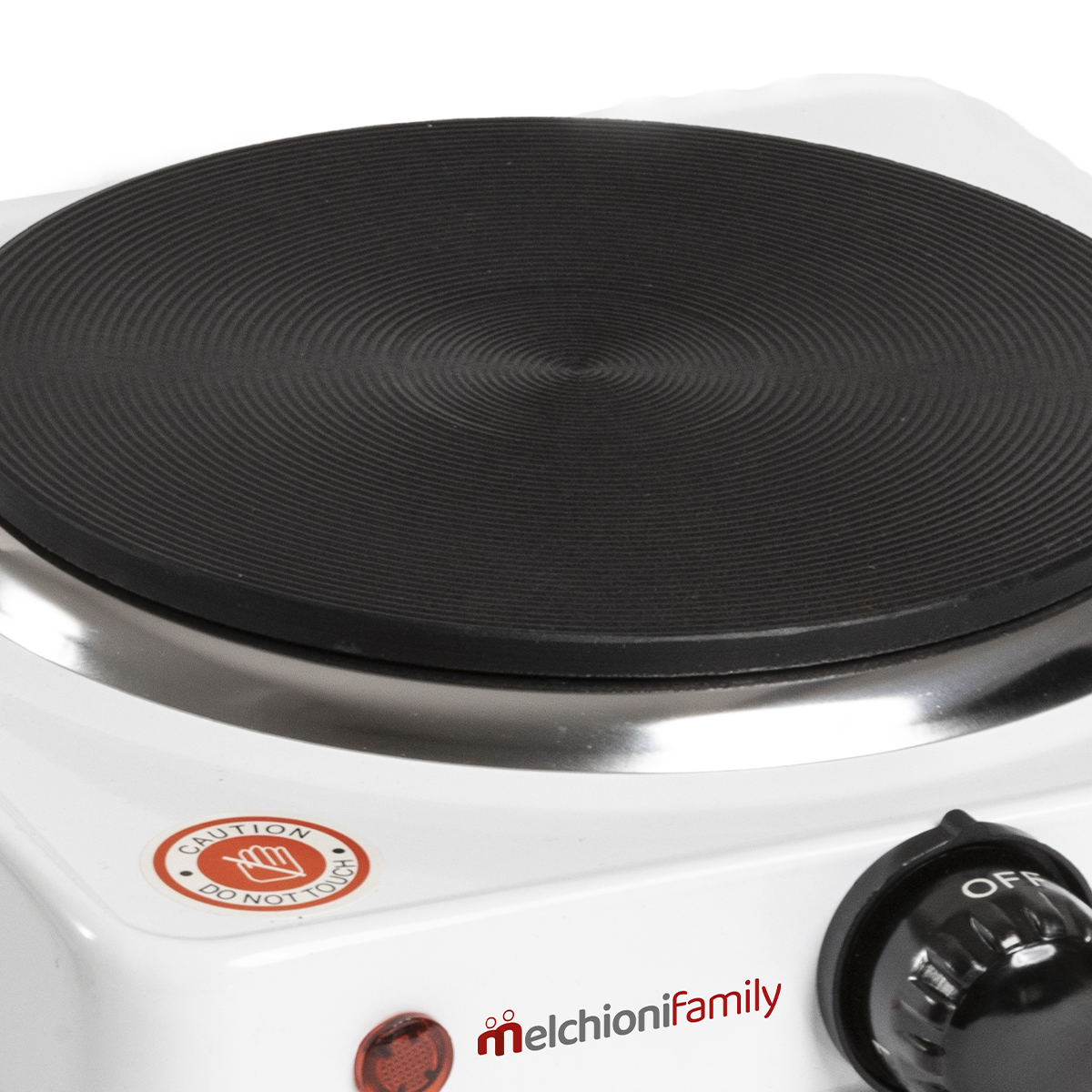 Zbliżenie czarnej elektrycznej płyty grzejnej na białej podstawie. Widoczne pokrętło. Etykieta ostrzegawcza 'Nie dotykać'.