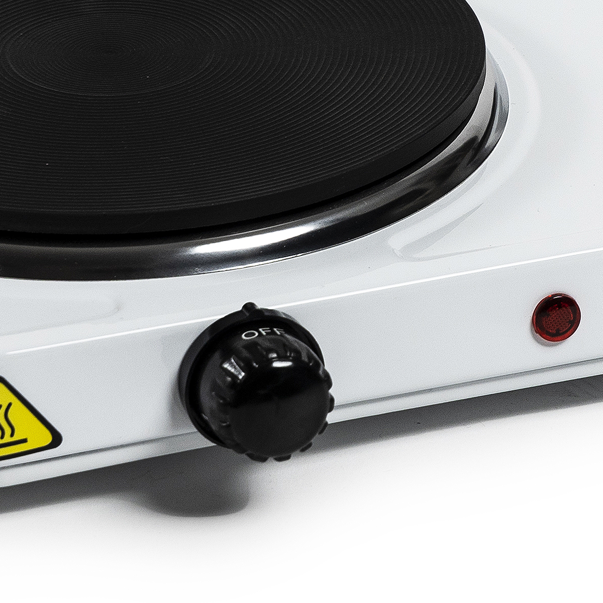 Zbliżenie białej elektrycznej płyty grzejnej. Posiada czarny element grzejny, pokrętło z napisem 'OFF' i czerwoną lampkę kontrolną.