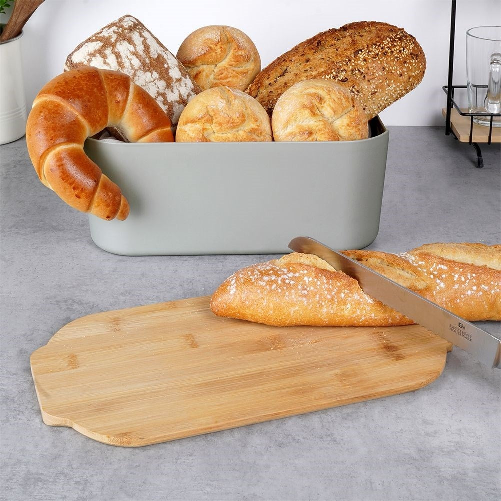Vari tipi di pane in un cestino, un croissant che sporge, una pagnotta tagliata su un tagliere con un coltello.
