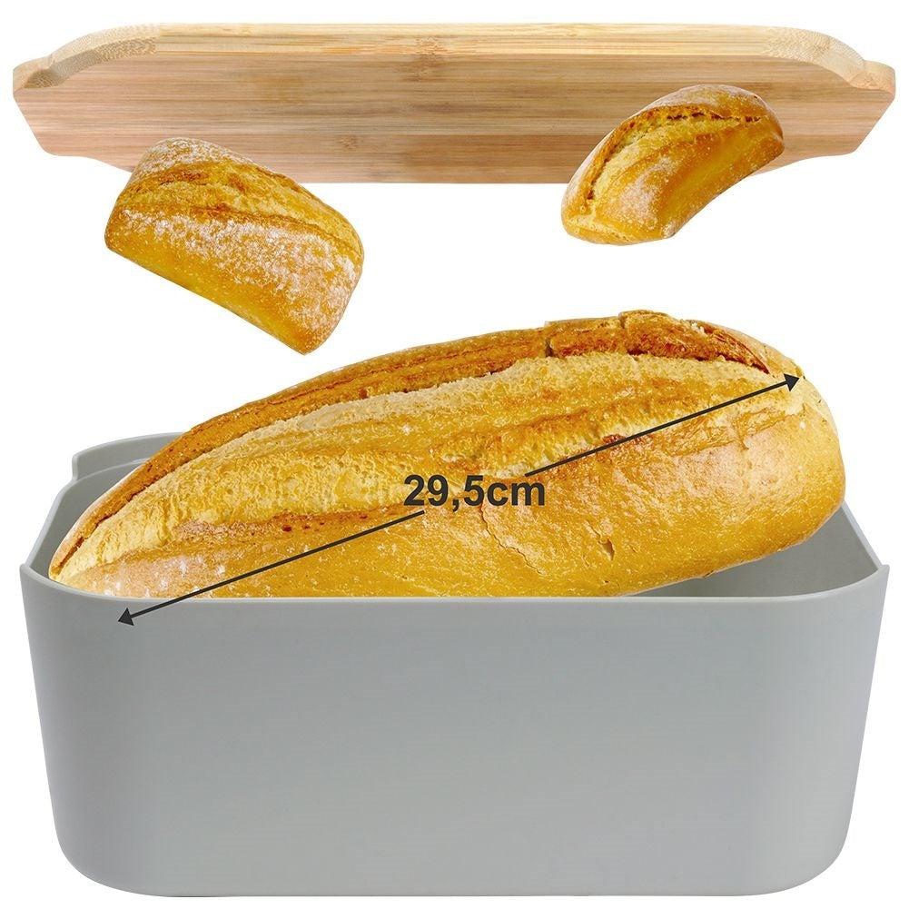 Una pagnotta in un contenitore grigio. Sono visibili anche due pezzi di pane più piccoli e un vassoio di legno.