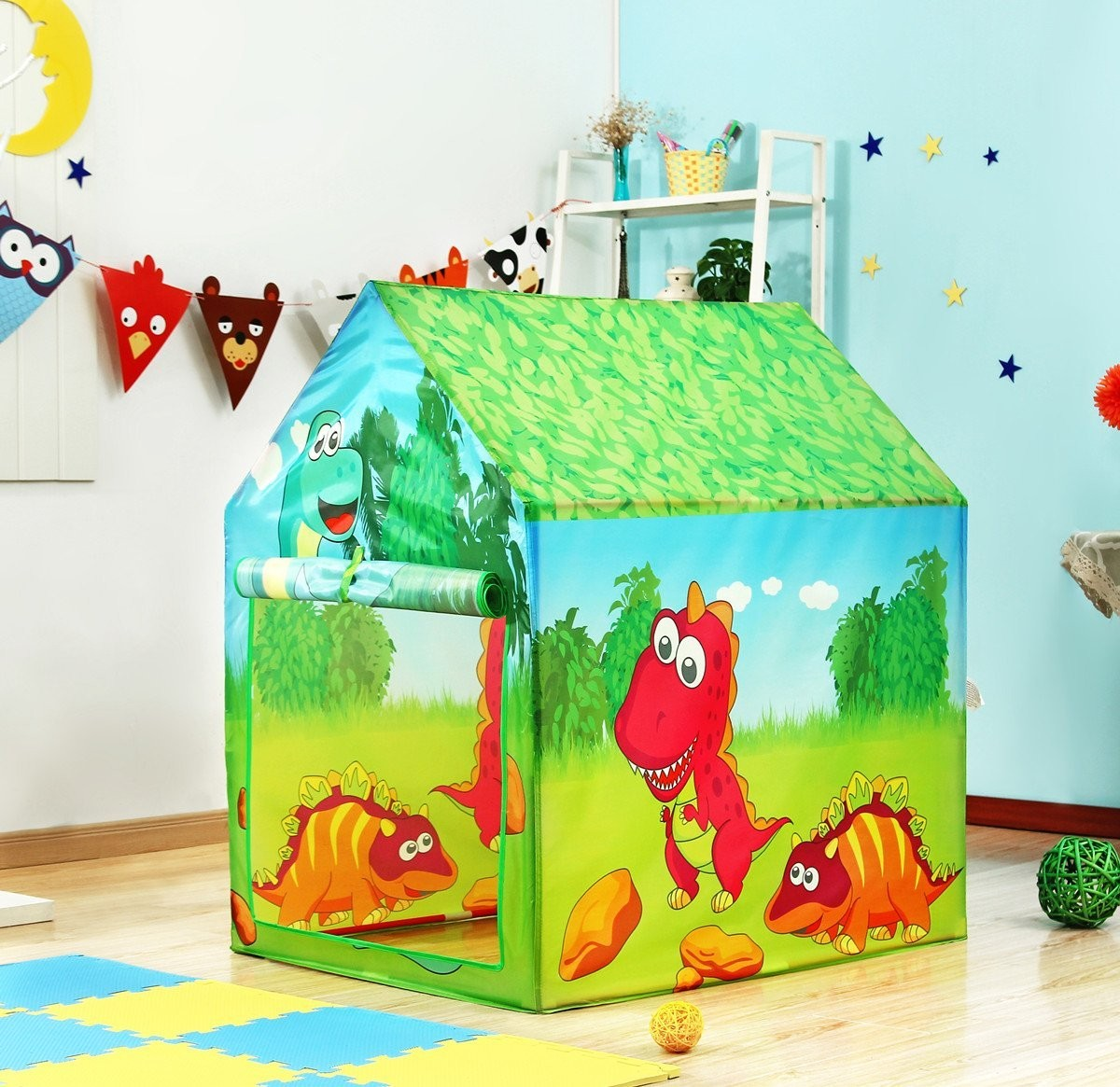 Una colorida casa de juegos con temática de dinosaurios se encuentra en un piso. La casa tiene techo verde y paredes con dinosaurios pintados.
