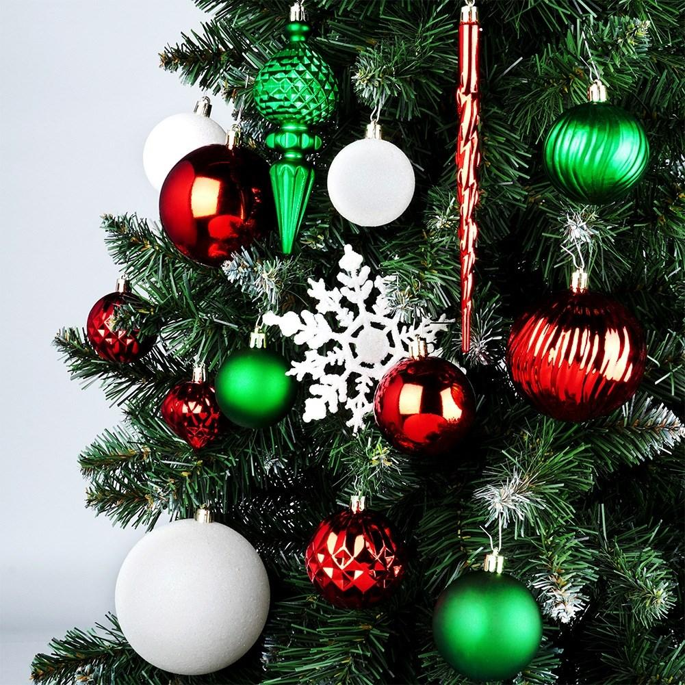 Un árbol de Navidad decorado con adornos rojos, verdes y blancos. También hay un adorno de copo de nieve blanco.