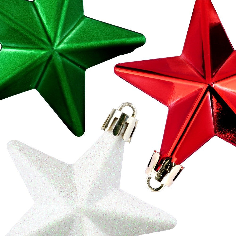 Primer plano de tres adornos de estrella: verde, rojo y blanco con purpurina. Cada estrella tiene una tapa plateada. El fondo es blanco.
