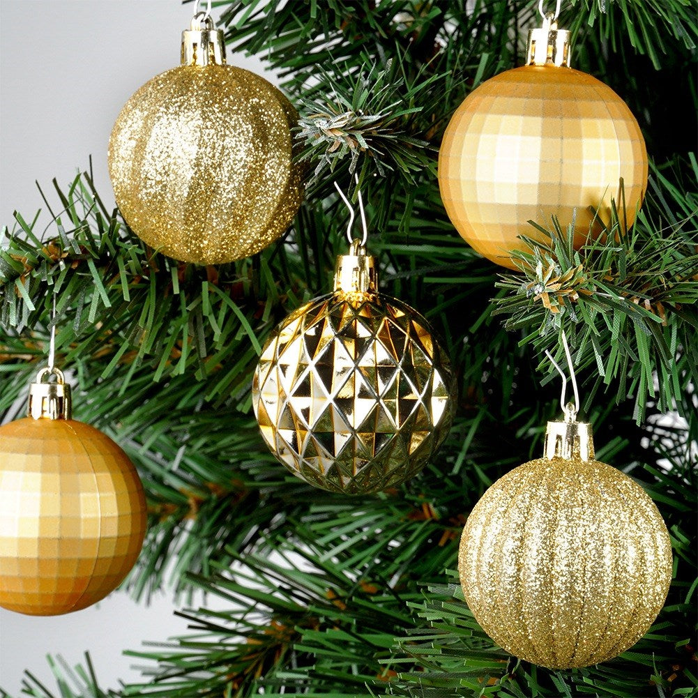 Primer plano de un árbol de Navidad con adornos dorados. Los adornos tienen diferentes texturas, incluyendo brillo y patrones geométricos.