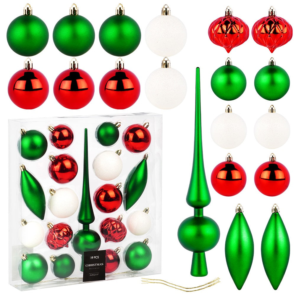 Adornos navideños: bolas verdes, rojas, blancas, pináculos verdes y formas de lágrima, algunos en una caja. Decoraciones festivas y coloridas.