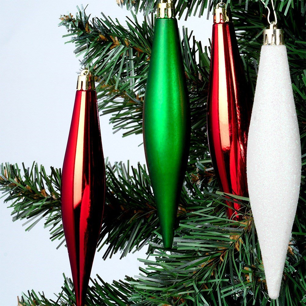 Primer plano de adornos navideños: formas de lágrima rojas, verdes y blancas colgadas de un árbol de Navidad verde, fondo blanco.