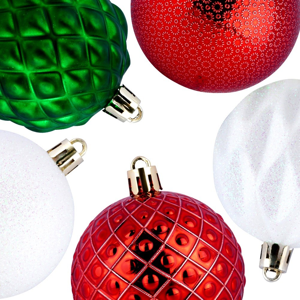 Primer plano de adornos navideños. Hay cinco adornos: verde, rojo y blanco. Tienen diferentes texturas y patrones. Fondo blanco.