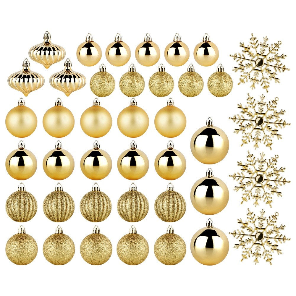 Varios adornos navideños dorados, incluyendo bolas, gotas y copos de nieve, dispuestos sobre un fondo blanco.