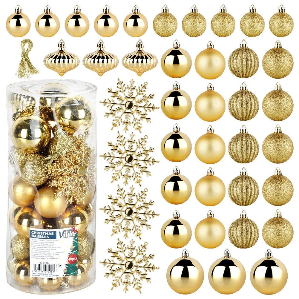 Una colección de adornos navideños dorados, incluyendo bolas, copos de nieve y formas decorativas, algunos en un recipiente transparente.
