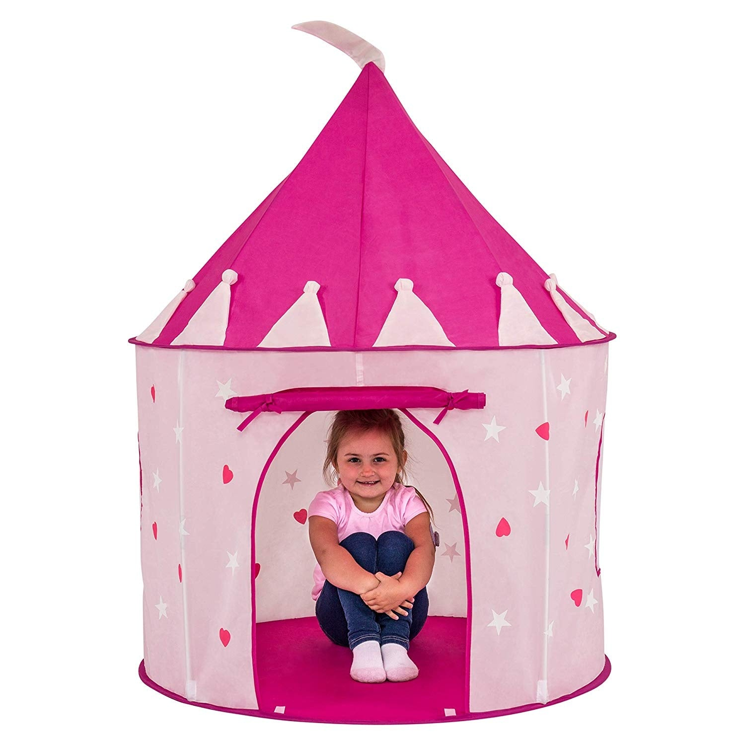 Una niña está sentada en una tienda de juegos rosa decorada con corazones y estrellas. La tienda tiene un techo rosa y una bandera blanca.
