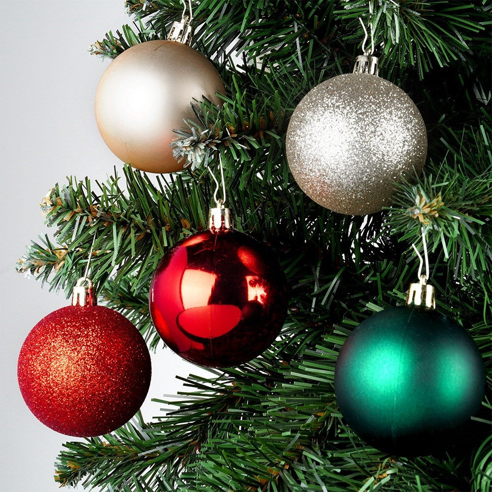Árbol de Navidad con cinco adornos. Los colores incluyen dorado, plateado, rojo y verde. Los adornos son redondos y cuelgan.