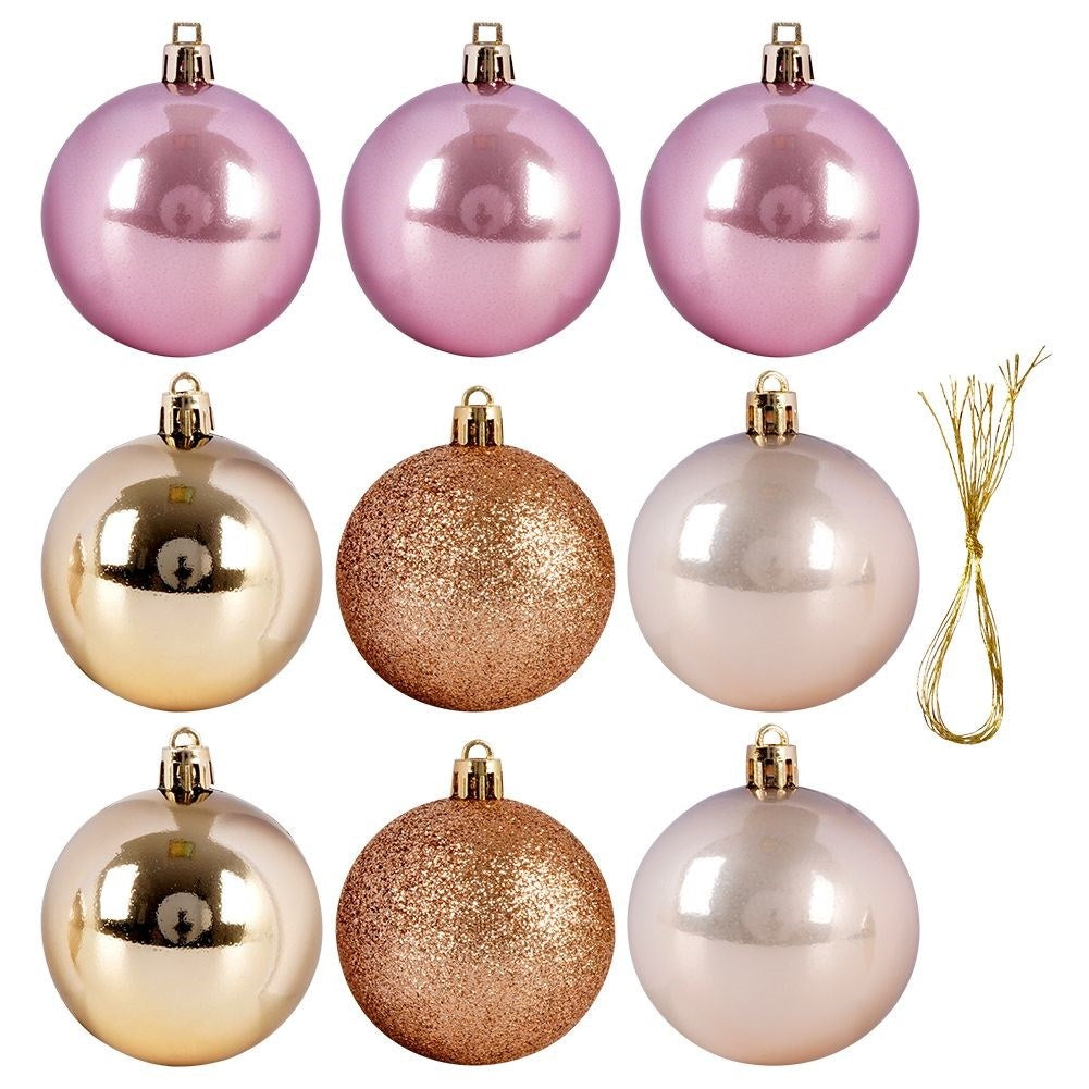 Nueve bolas de Navidad en rosa, dorado y blanco. Algunas brillantes, otras con purpurina. Cuerda dorada a la derecha.