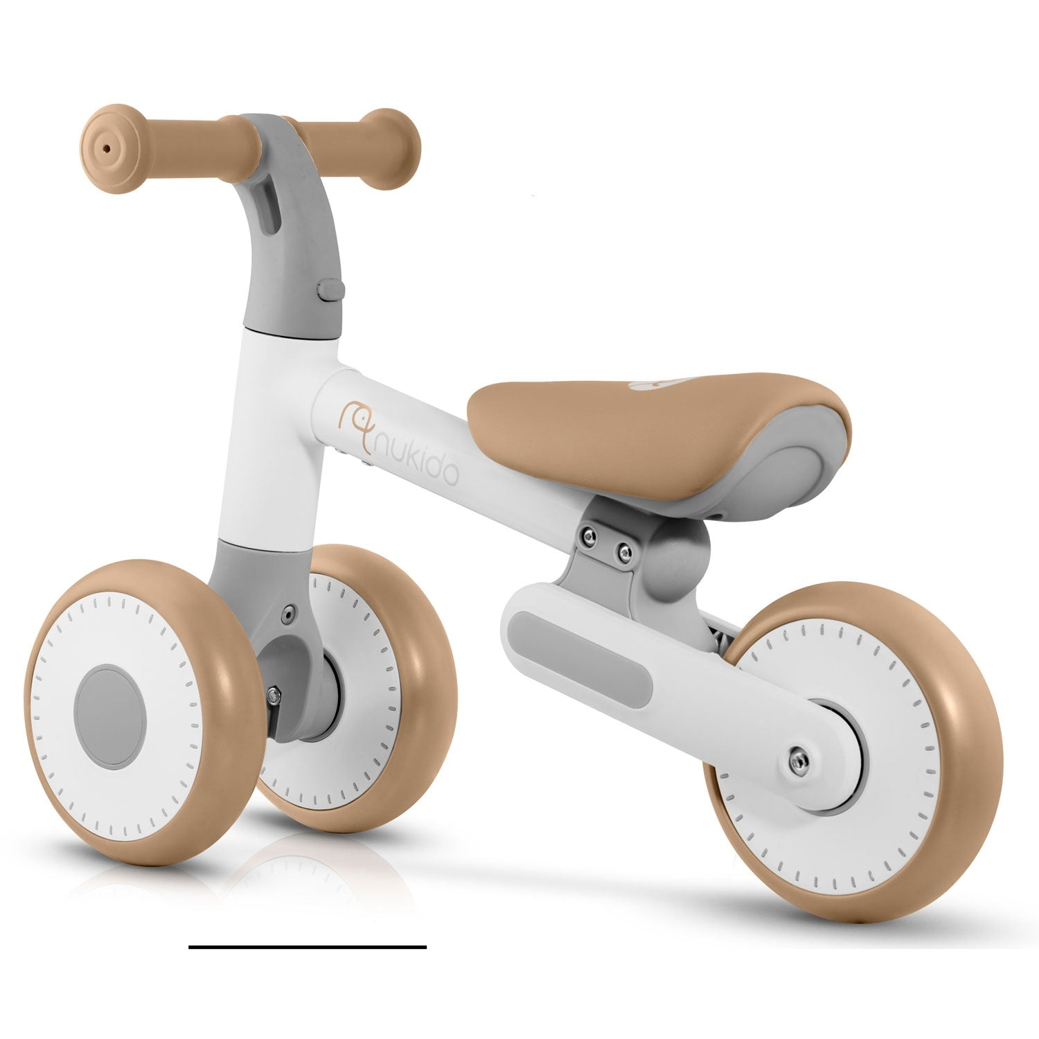 Una bicicleta de equilibrio blanca y marrón claro para un niño. Tiene ruedas y asiento color canela, con marco y manillar grises.
