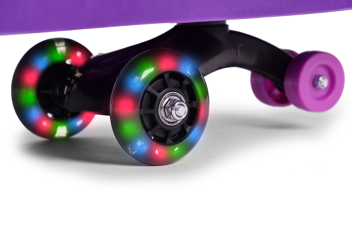 Primer plano de las ruedas de un patinete morado. Las ruedas tienen luces LED de colores. El patinete está sobre una superficie blanca.